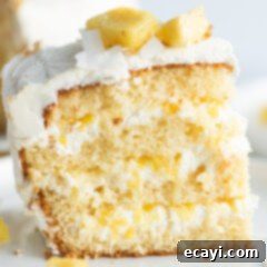 Golden Pineapple Bliss 12 A slice of Pineapple Cake on a plate, showing the moist layers, creamy filling, and fluffy frosting.