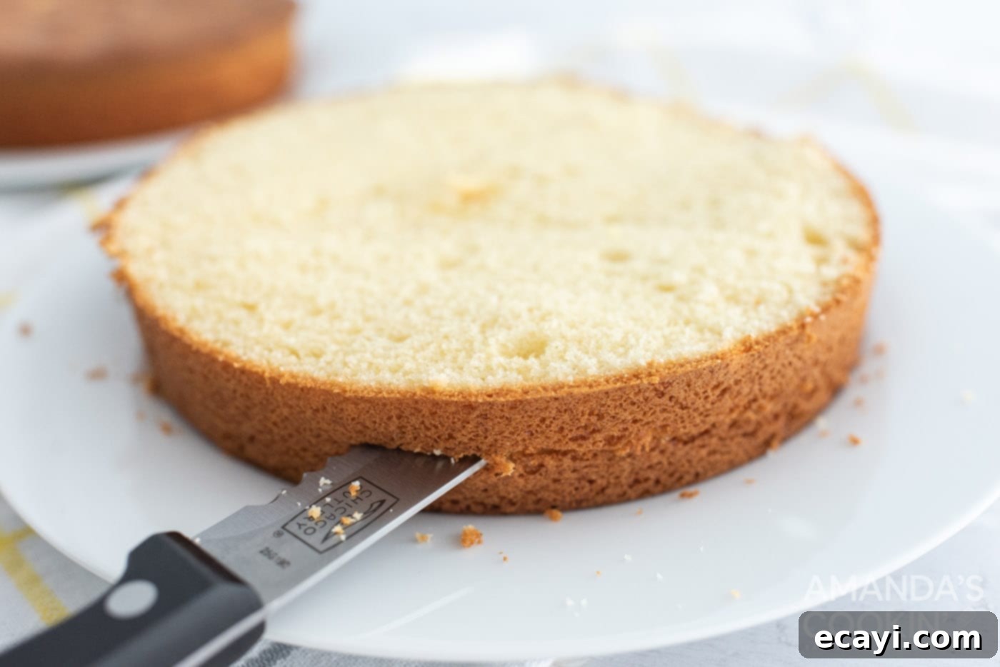 Golden Pineapple Bliss 7 A knife carefully slicing a cooled cake layer horizontally into two thinner layers.