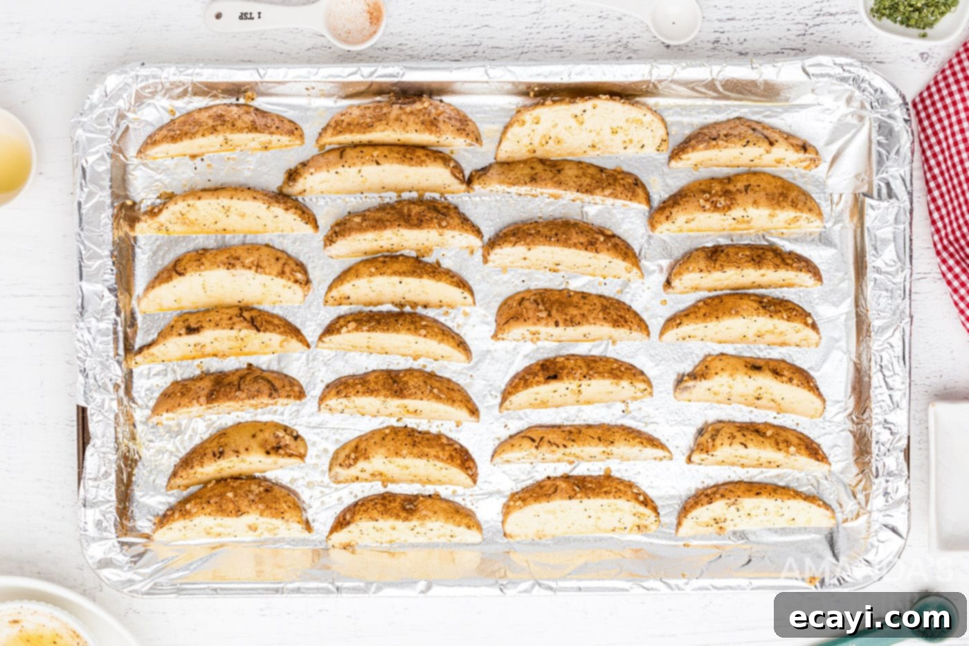Golden Spiced Wedges 8 Potato wedges arranged on a foil-lined baking sheet
