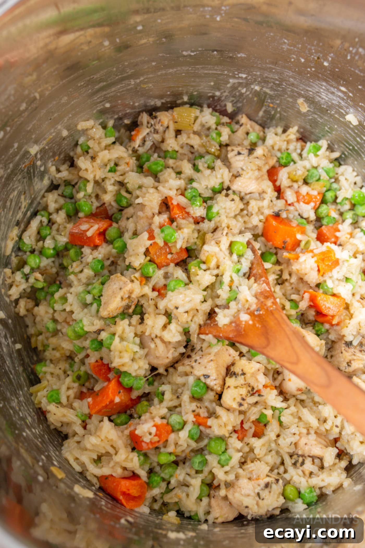 Effortless Instant Pot Chicken and Rice 9 Stirring the finished Instant Pot chicken and rice to combine all ingredients