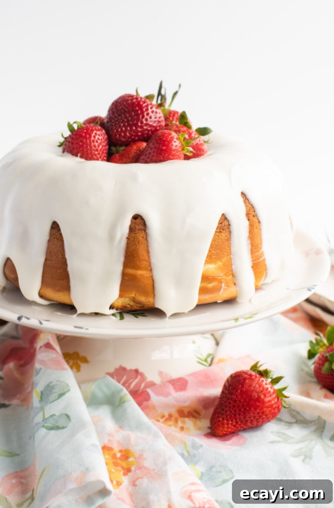 Summer Strawberry Bundt Delight 2 show-stopping strawberry bundt cake on an elegant cake plate, garnished with fresh strawberries