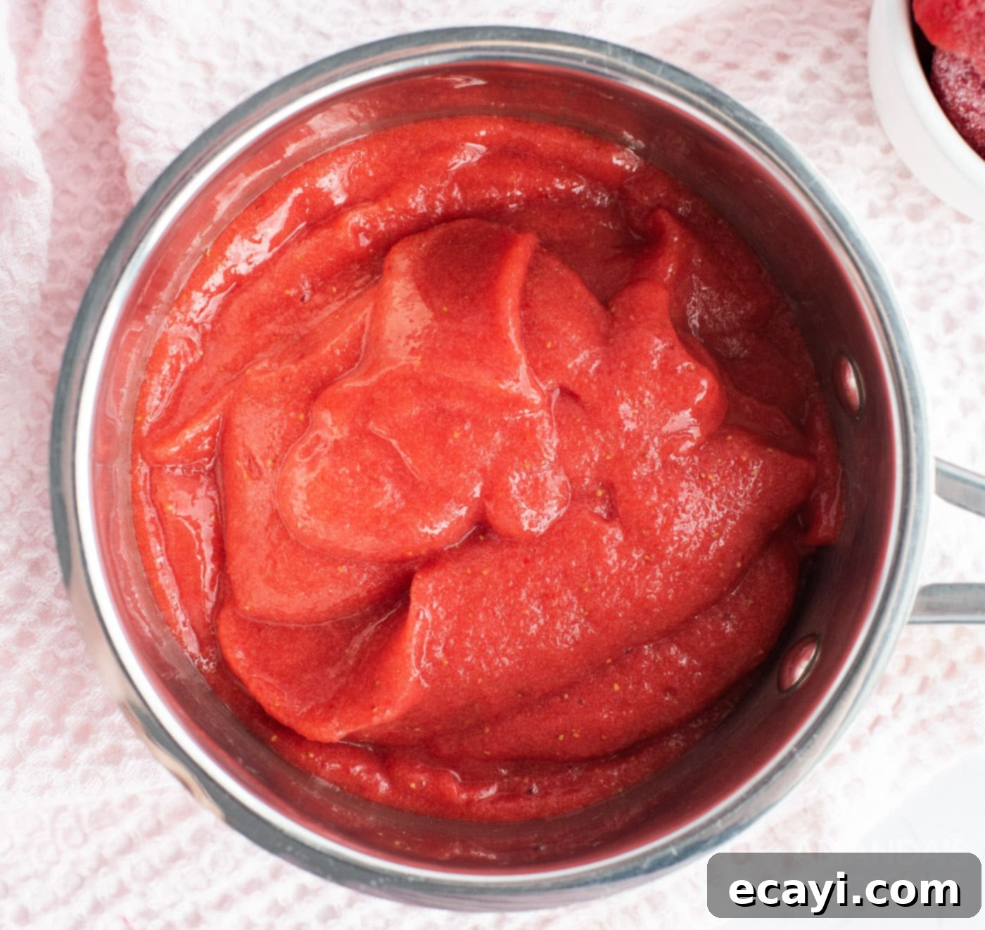 Summer Strawberry Bundt Delight 6 strawberry puree simmering in a pan to reduce