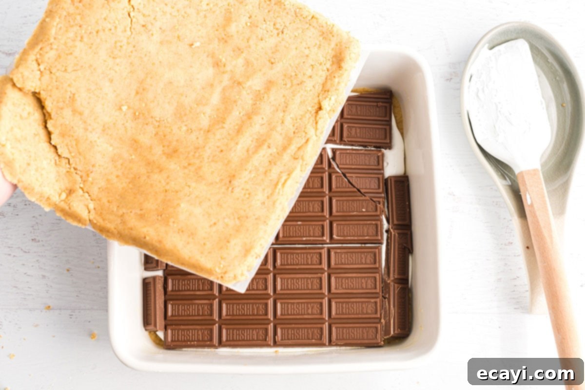 Ultimate Smores Bars 12 placing dough on top of chocolate layer