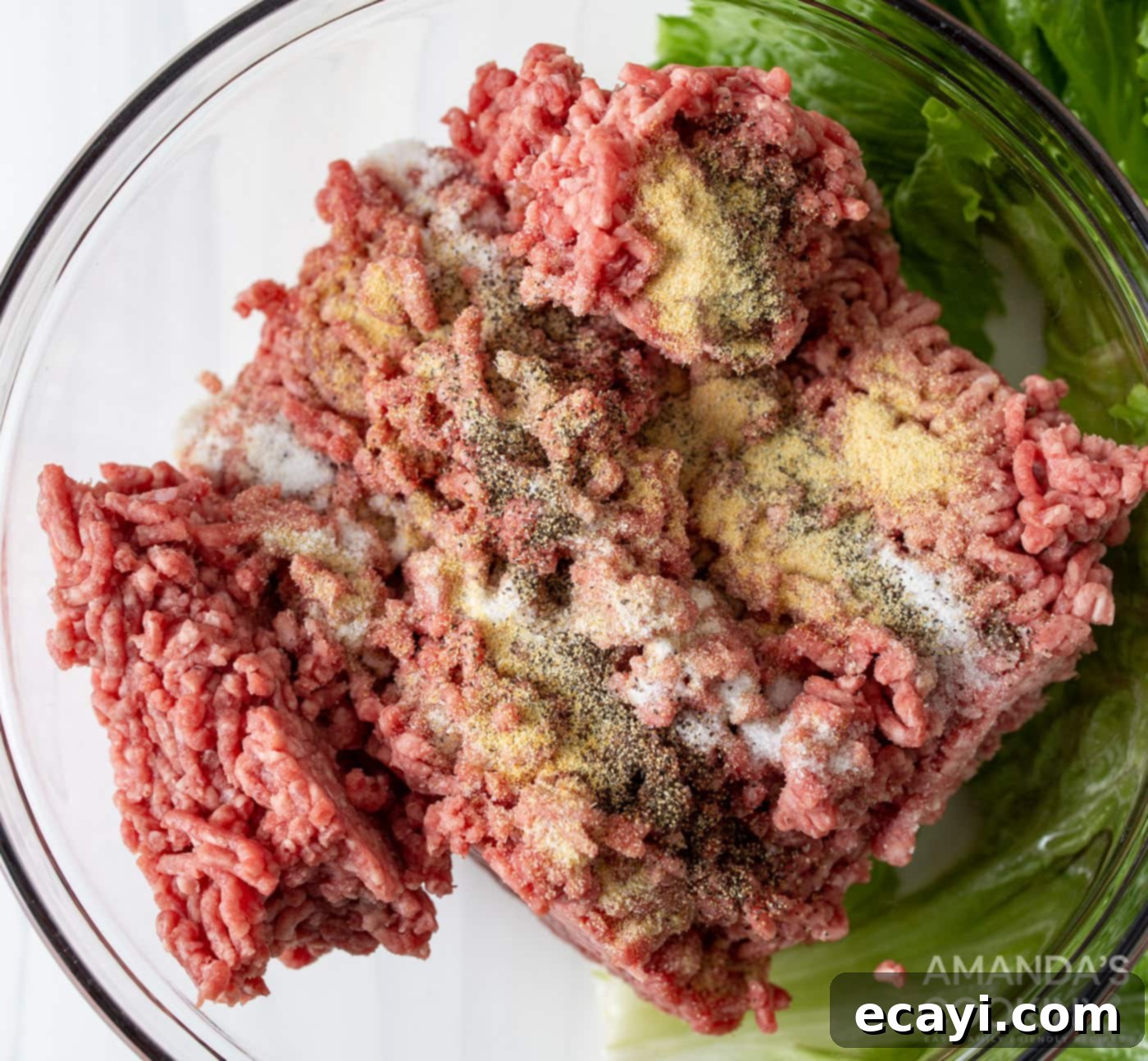Mini Bacon Cheeseburger Poppers 5 Raw ground beef mixed with seasonings in a stainless steel bowl, ready to be formed into meatballs.