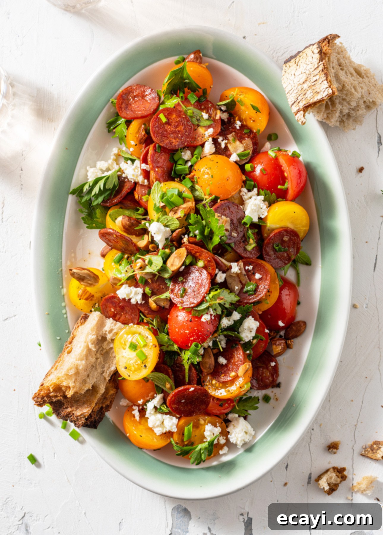 Vibrant Spanish Chorizo Tomato Salad with Toasted Almonds 2 Vibrant Spanish Tomato Salad with crispy chorizo, crumbled feta, and toasted almonds served on a plate.