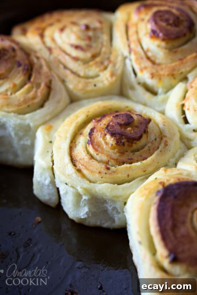 Mouthwatering Garlic Parmesan Rolls 2 A close up of freshly baked, golden brown Parmesan garlic rolls, glistening with butter.