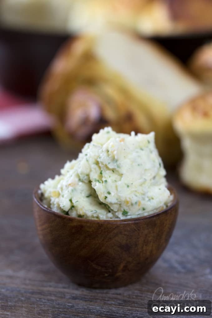 Mouthwatering Garlic Parmesan Rolls 3 A close up of a small wooden bowl brimming with homemade garlic butter, showcasing minced garlic and herbs.