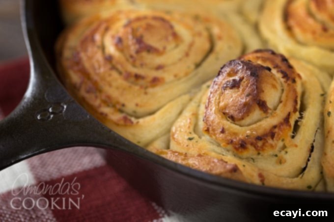Mouthwatering Garlic Parmesan Rolls 5 A close up of a round cast iron pan filled with golden brown Parmesan garlic rolls, fresh from the oven.