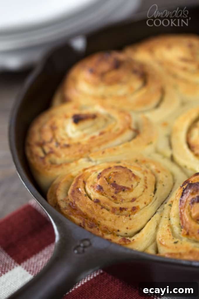 Mouthwatering Garlic Parmesan Rolls 9 A close up of freshly baked, golden brown Parmesan garlic rolls in a cast iron skillet, ready to be devoured.