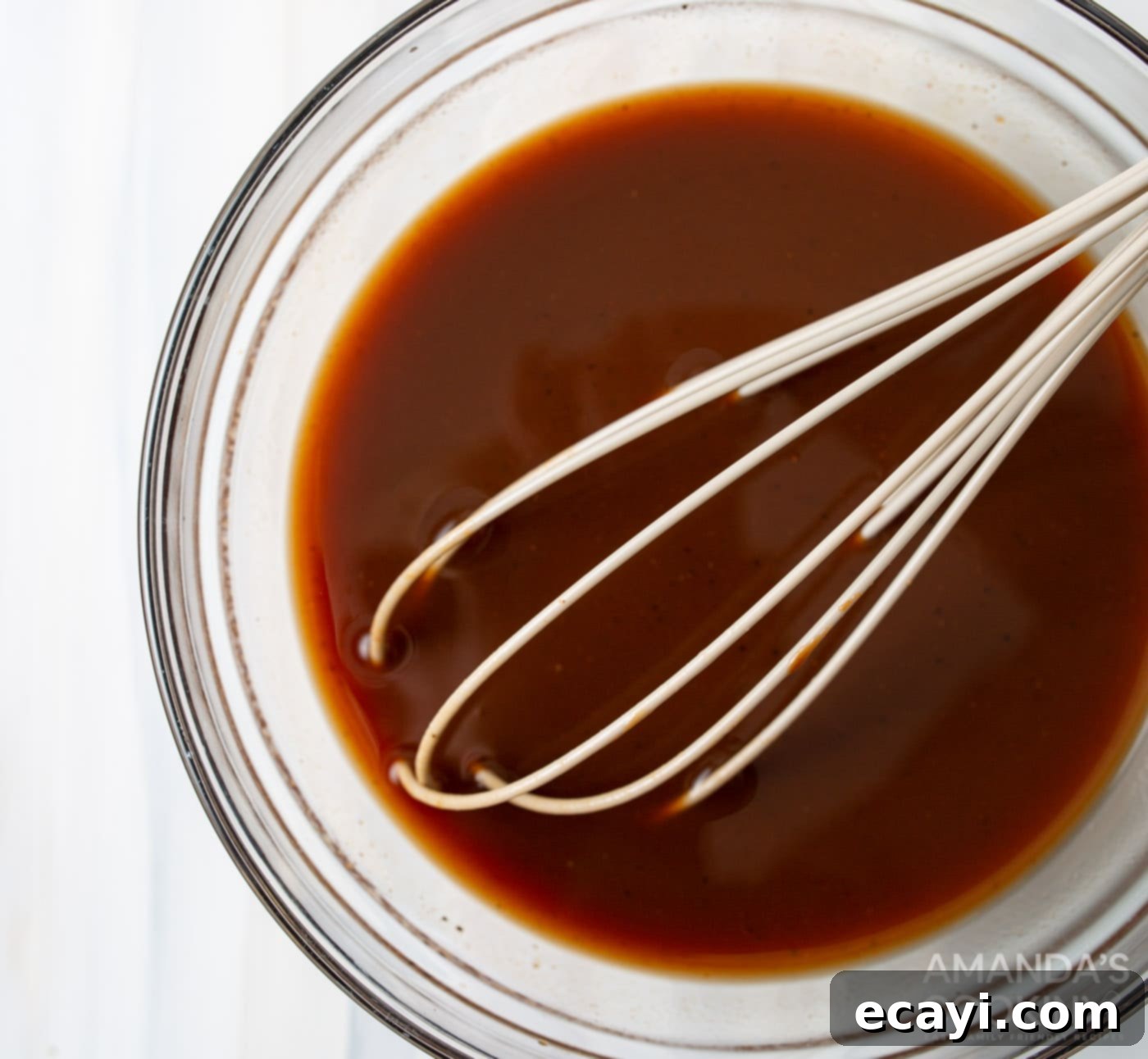 Perfectly Tender Instant Pot Pulled Pork 8 pulled pork sauce in a bowl with whisk
