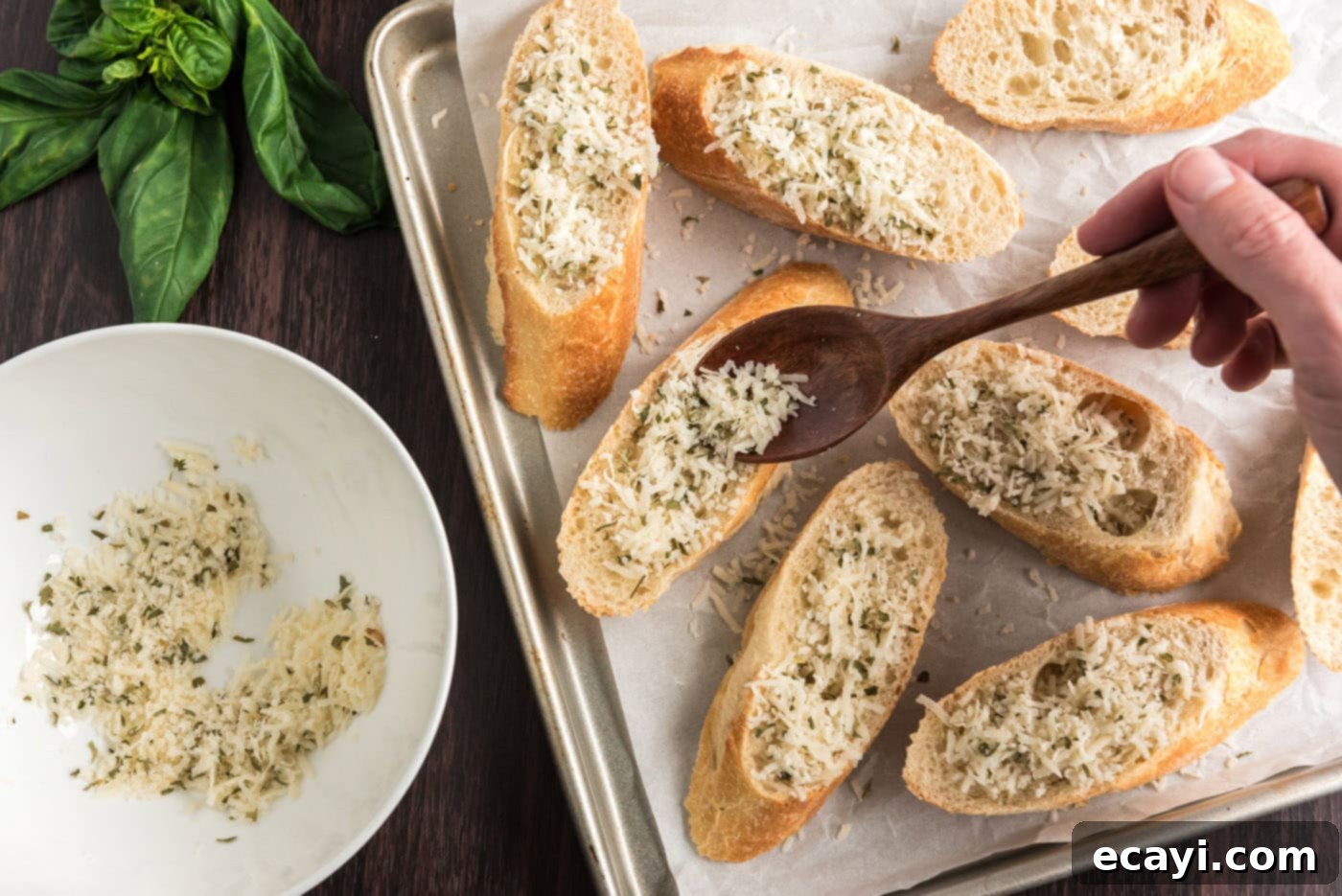Crafting Perfect Bruschetta 6 Hand sprinkling Parmesan cheese and dried herbs over bread slices on a baking sheet before toasting.