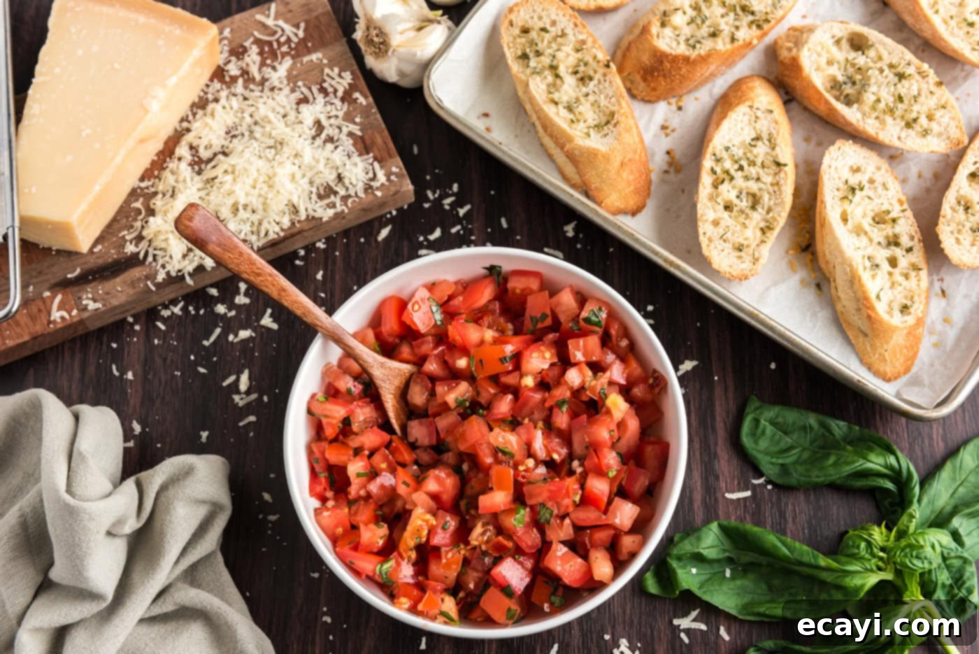 Crafting Perfect Bruschetta 9 A serving bowl filled with the fresh bruschetta tomato mixture, placed next to a stack of toasted bread slices with Parmesan.