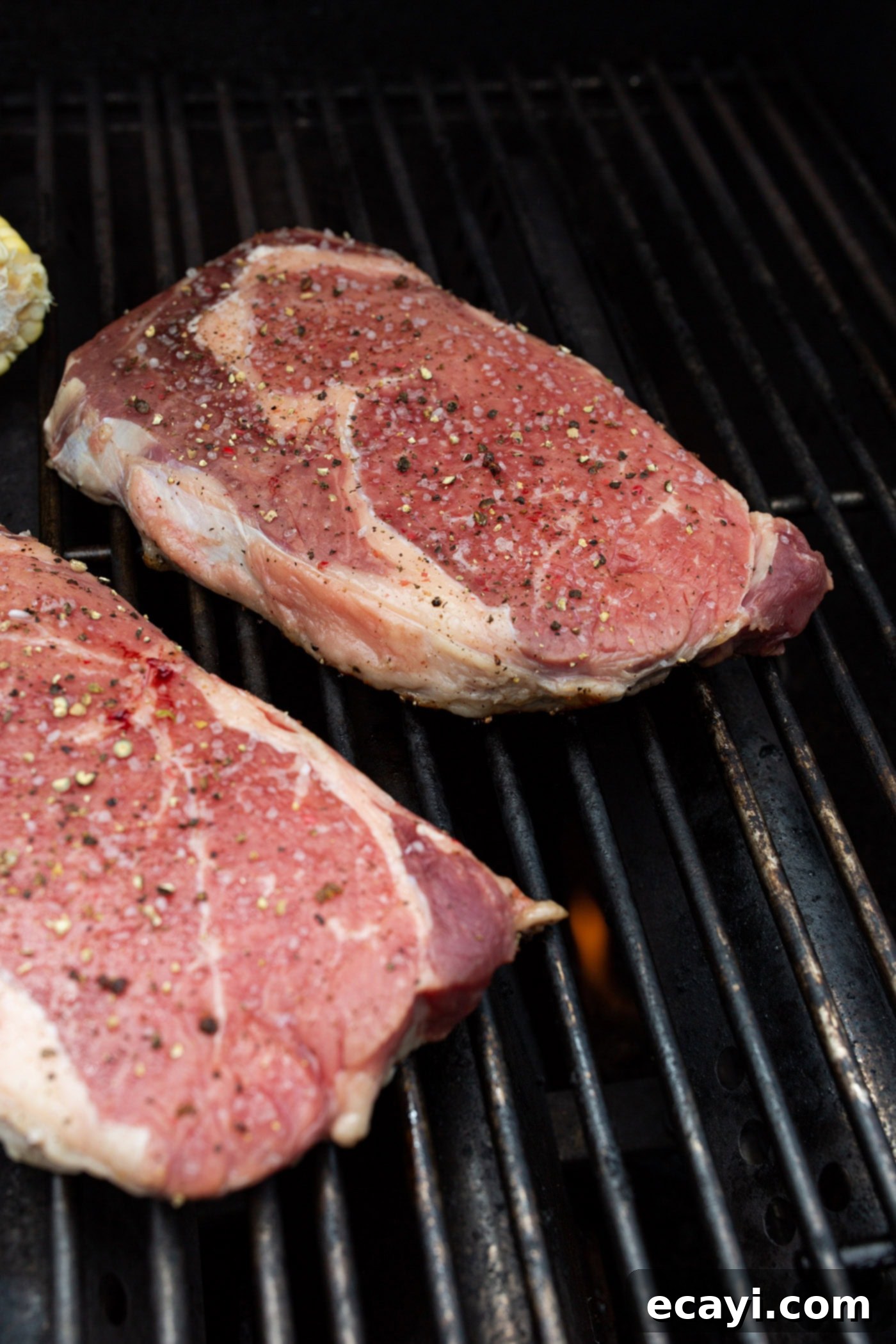 Perfectly Grilled Steak 6 New York strip steaks searing on a hot grill, developing a delicious crust
