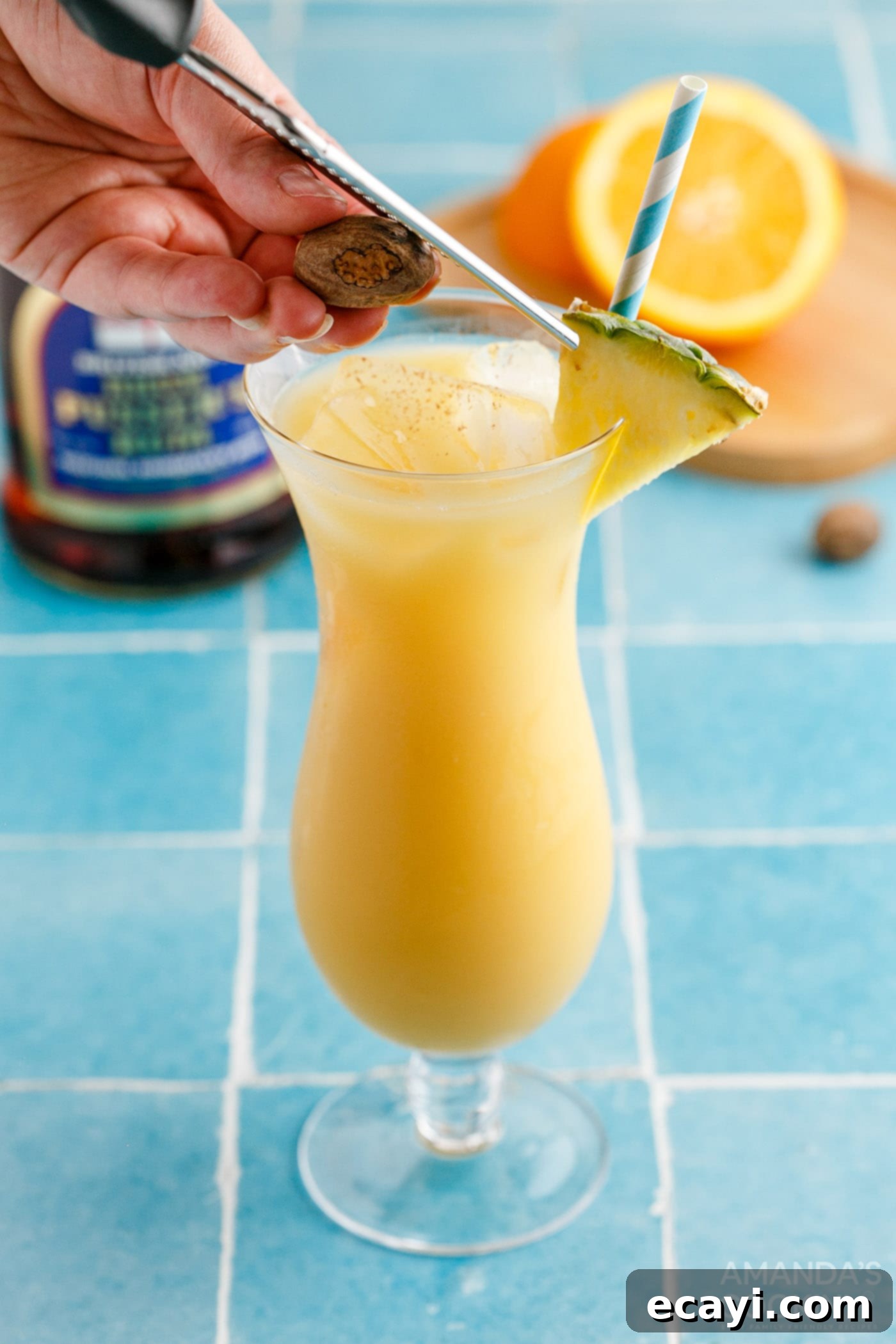 Paradise Potion 8 Adding a pineapple wedge garnish to a finished Painkiller cocktail