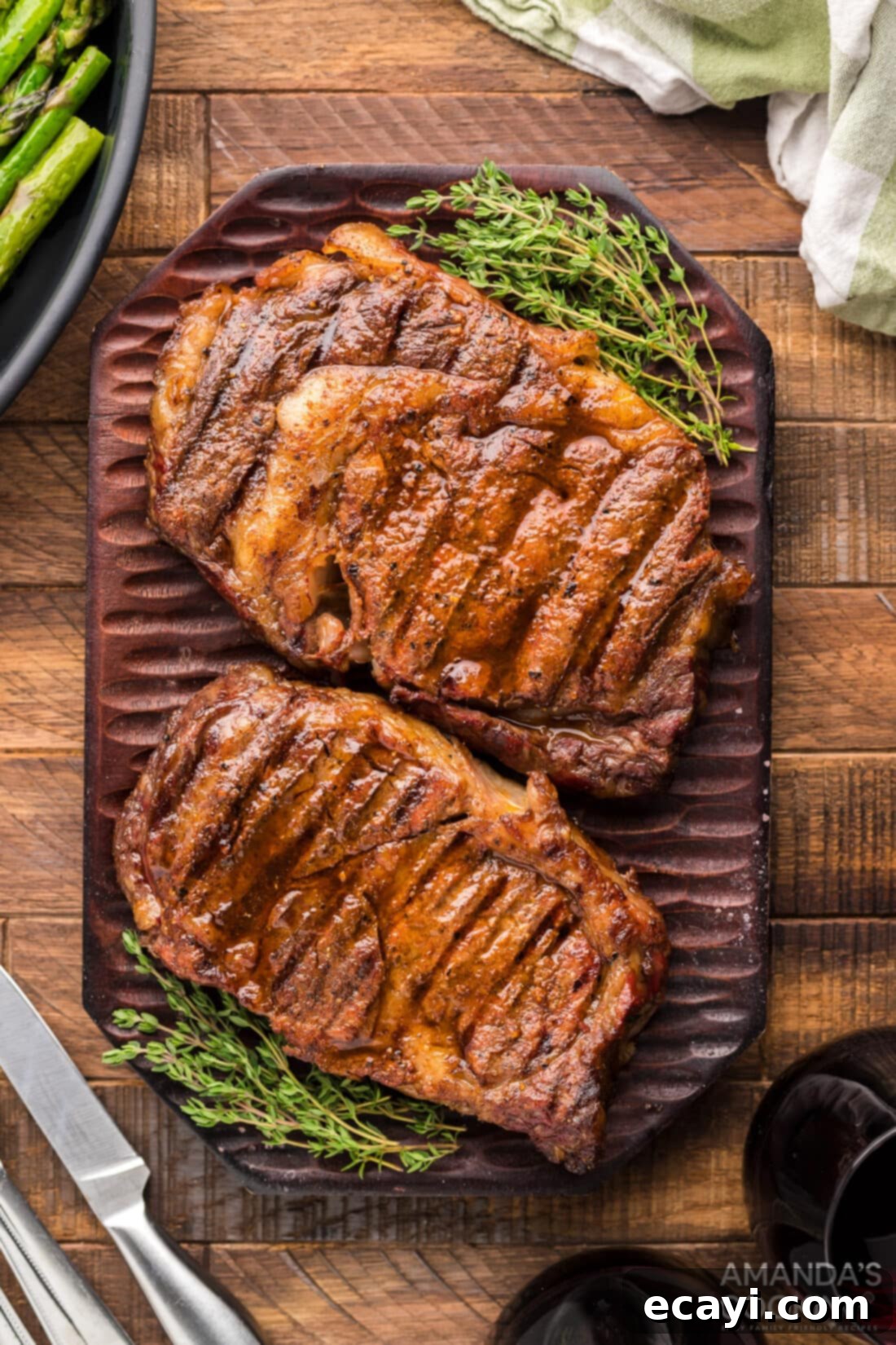 Slow-Smoked Ribeye 2 Two perfectly smoked ribeye steaks resting on a rustic cutting board, ready to be sliced and served.