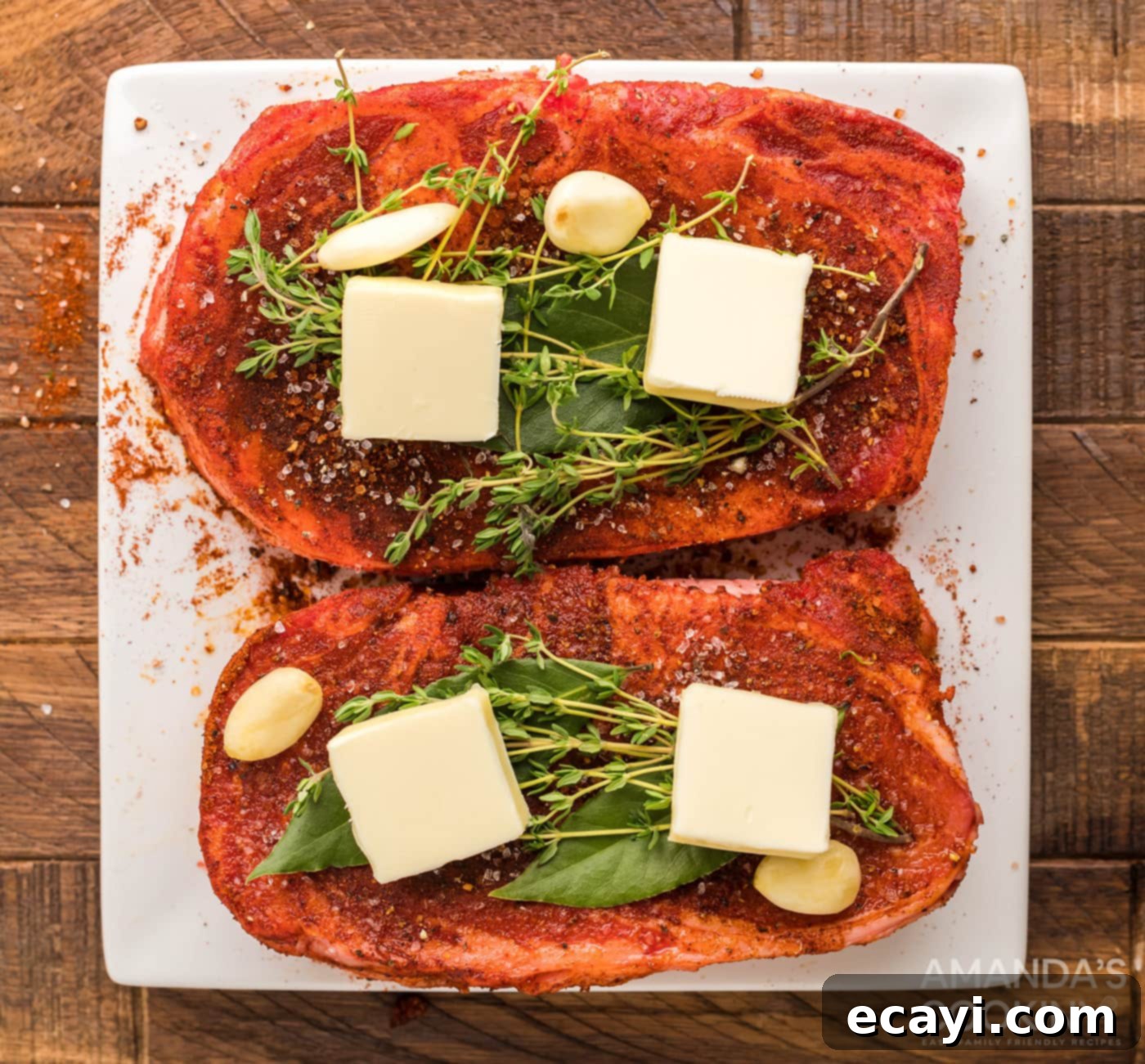 Slow-Smoked Ribeye 7 Ribeye steaks topped with pats of cold butter, fresh thyme sprigs, bay leaves, and garlic cloves before smoking.
