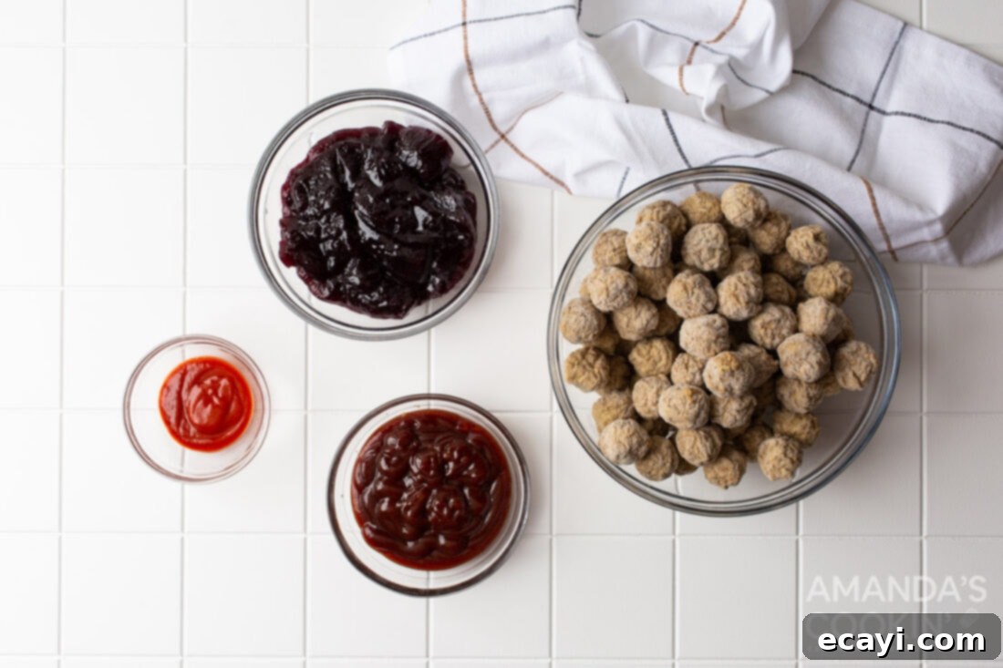 Sticky Grape Glazed Meatballs 4 An overhead shot showing the four simple ingredients: frozen meatballs, grape jelly, BBQ sauce, and sriracha.