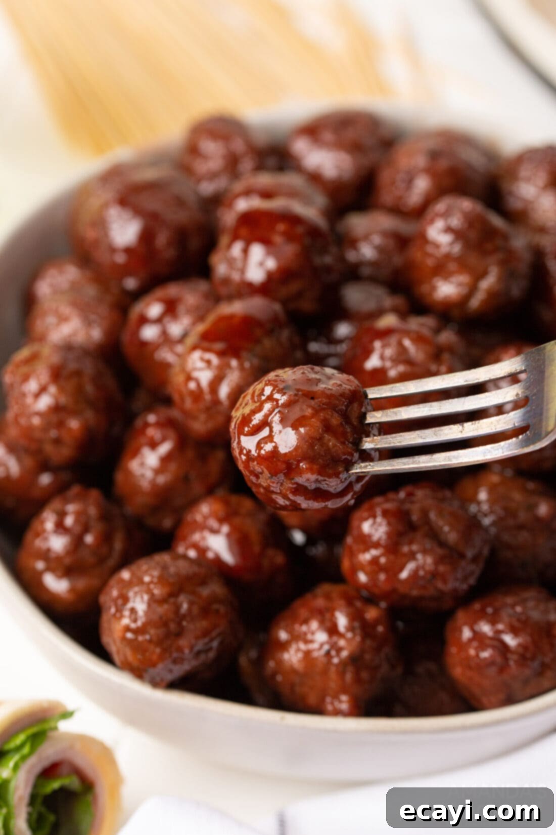 Sticky Grape Glazed Meatballs 5 A beautifully arranged bowl of Crockpot grape jelly meatballs, ready to be served as an appetizer.