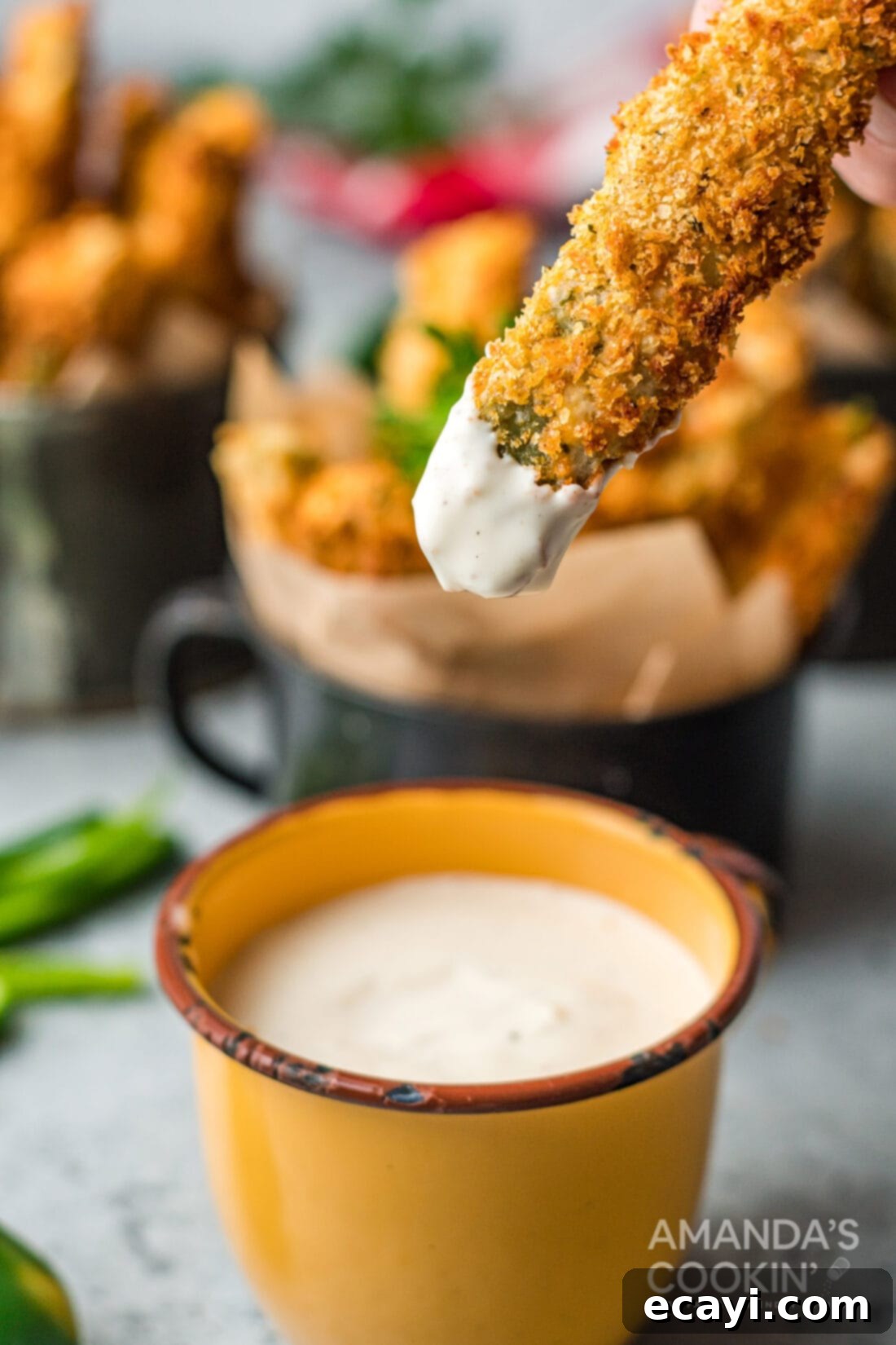 Crispy Air Fryer Jalapeño Fries 8 A hand dipping a perfectly golden and crispy Air Fryer Jalapeno Fry into a creamy sauce