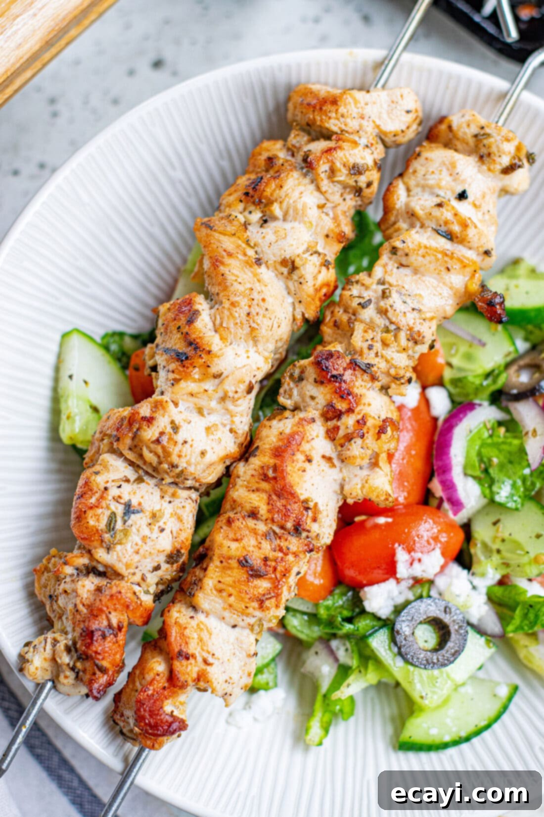 Lemon-Herb Mediterranean Chicken Skewers 3 Plated Greek Chicken Kabobs with a fresh salad and Tzatziki
