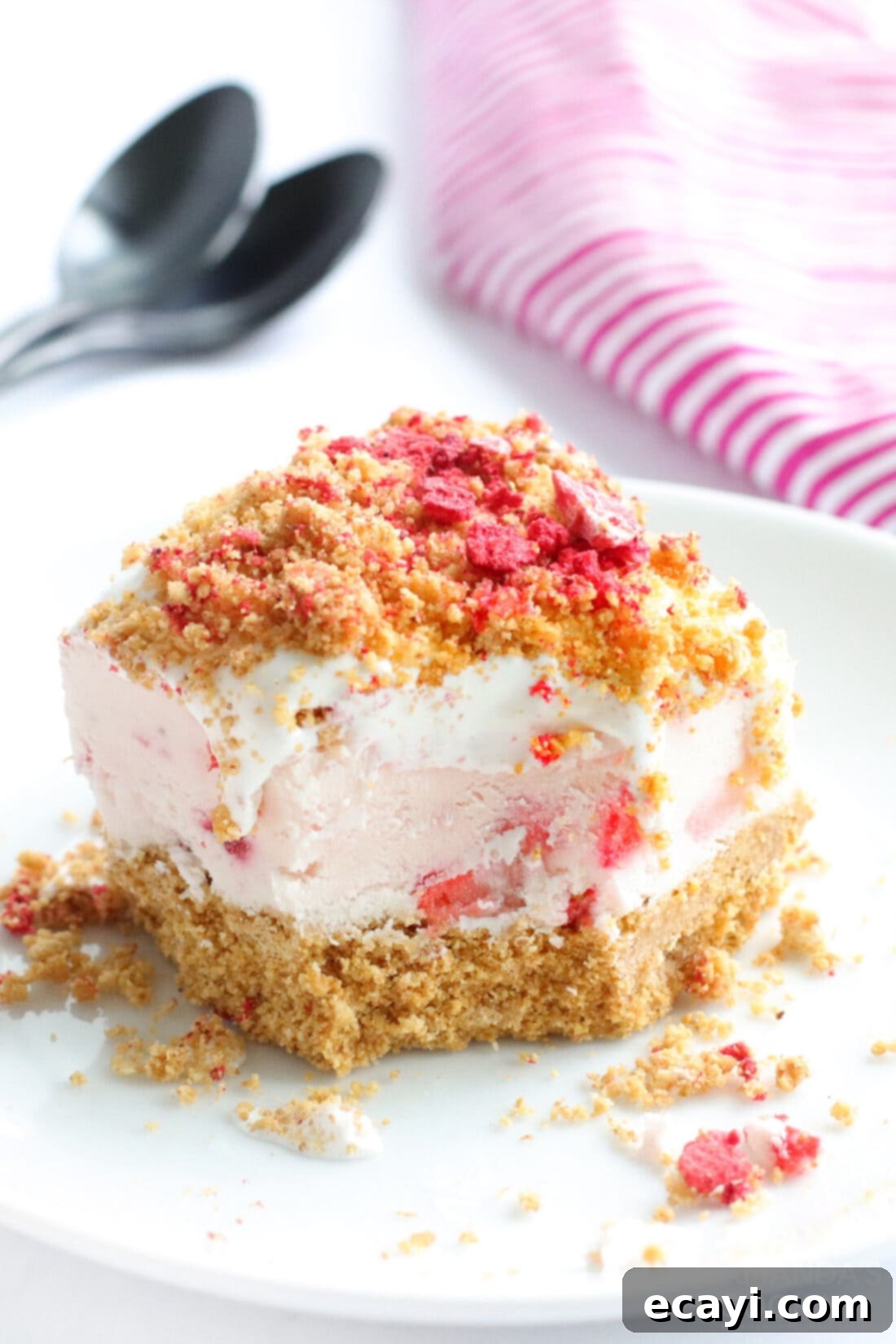 Effortless Strawberry Cheesecake Bars 11 No Bake Strawberry Cheesecake Bars with a bite taken out, showing the layers clearly