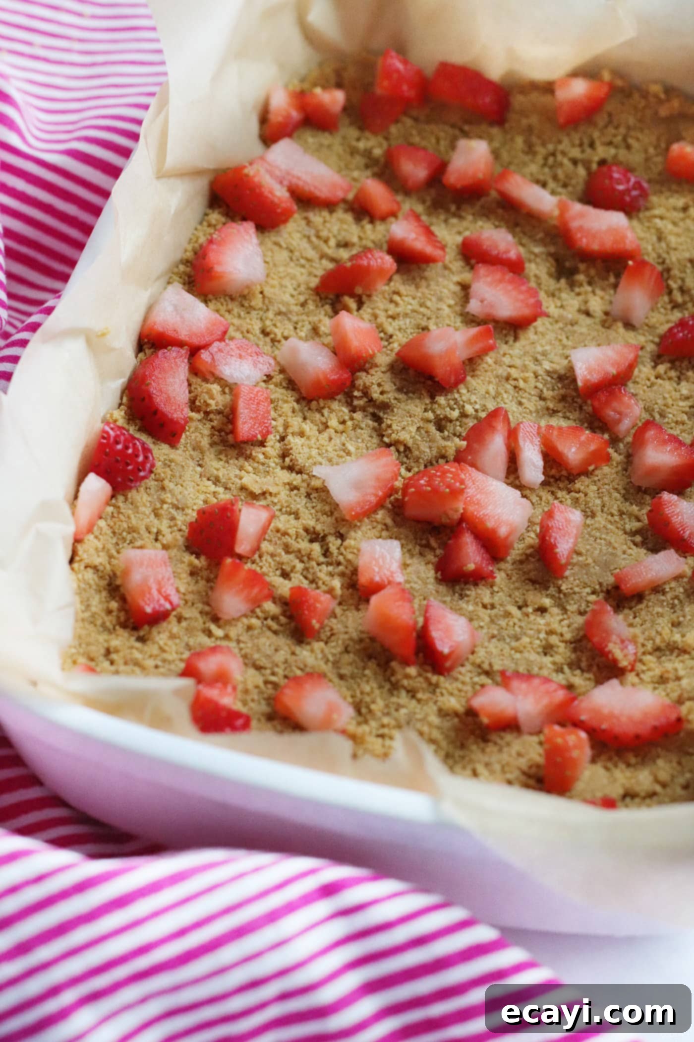 Effortless Strawberry Cheesecake Bars 7 chopped strawberries spread on top of the graham cracker crust