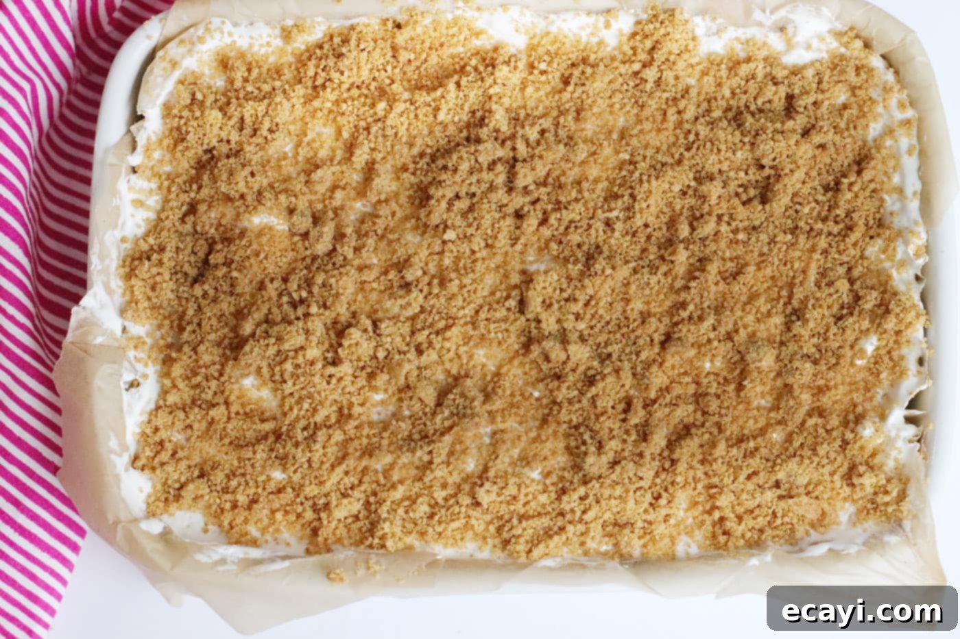 Effortless Strawberry Cheesecake Bars 9 graham cracker topping sprinkled over the cool whip layer on strawberry cheesecake bars