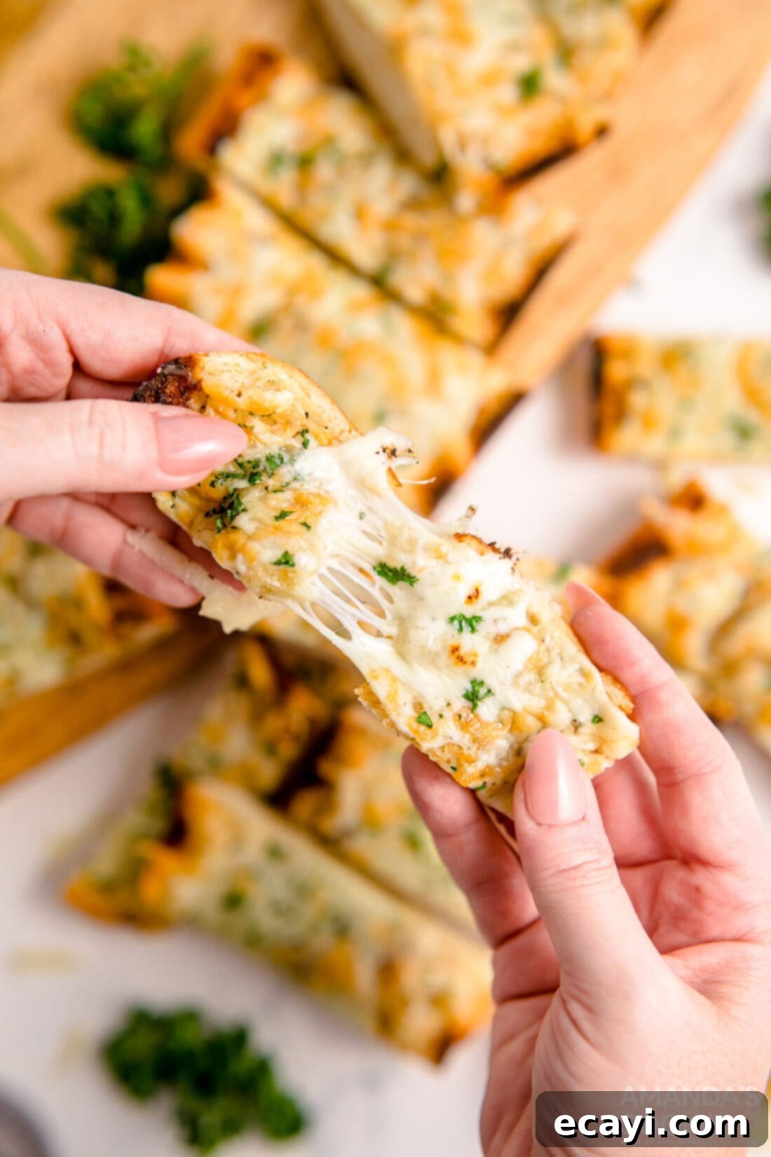 Garlic Cheese Bliss 2 A hand pulling a piece of golden-brown Cheesy Garlic Bread apart, showing melted mozzarella cheese strings