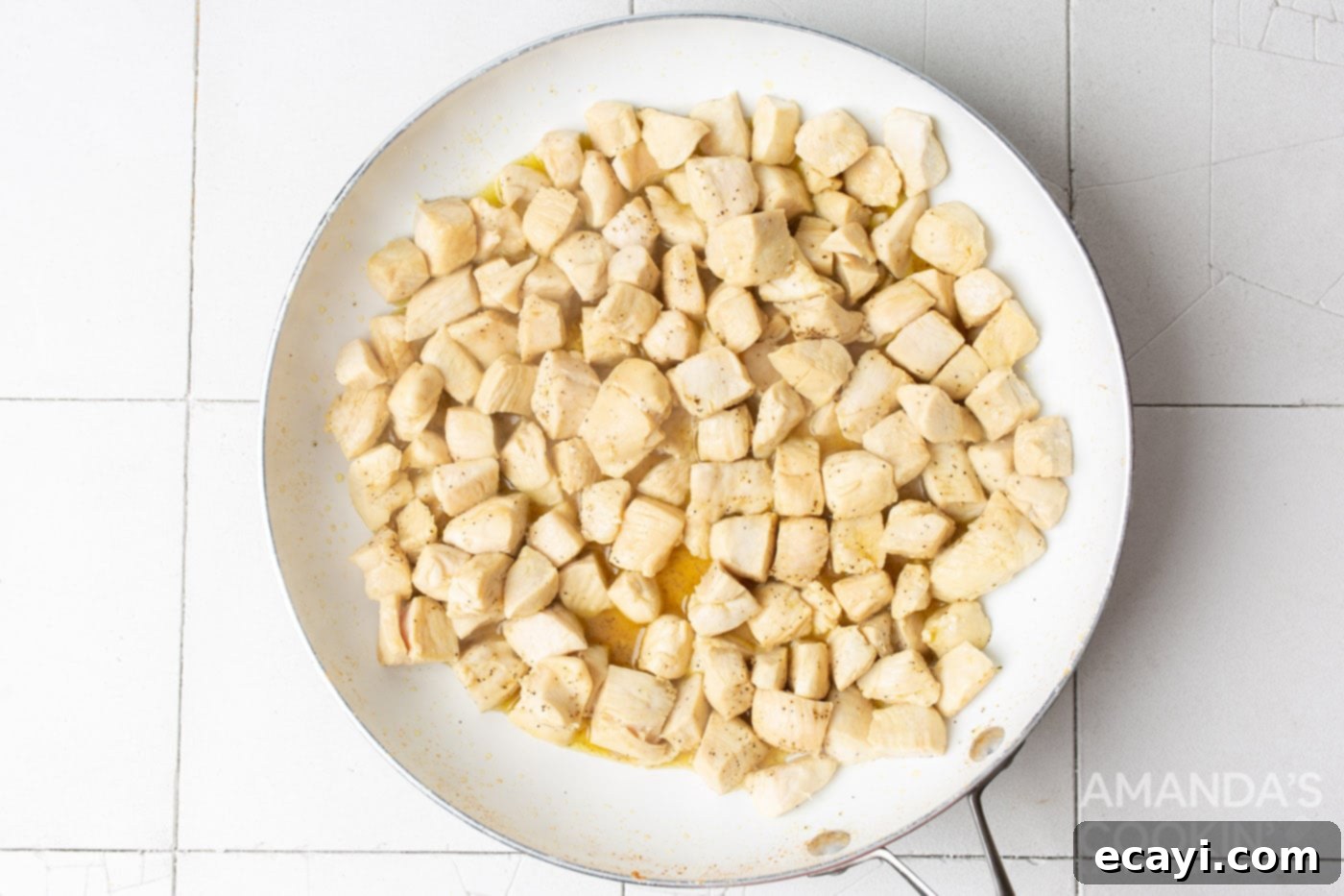 Creamy Chicken Spaghetti Bake 5 Cubed chicken cooking in a skillet, seasoned and browning.