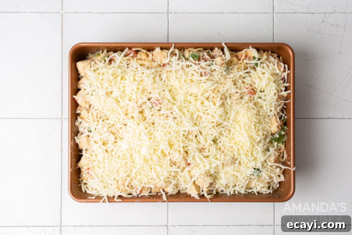 Creamy Chicken Spaghetti Bake 9 Shredded mozzarella and cheddar cheese topping a chicken spaghetti casserole in a baking dish.
