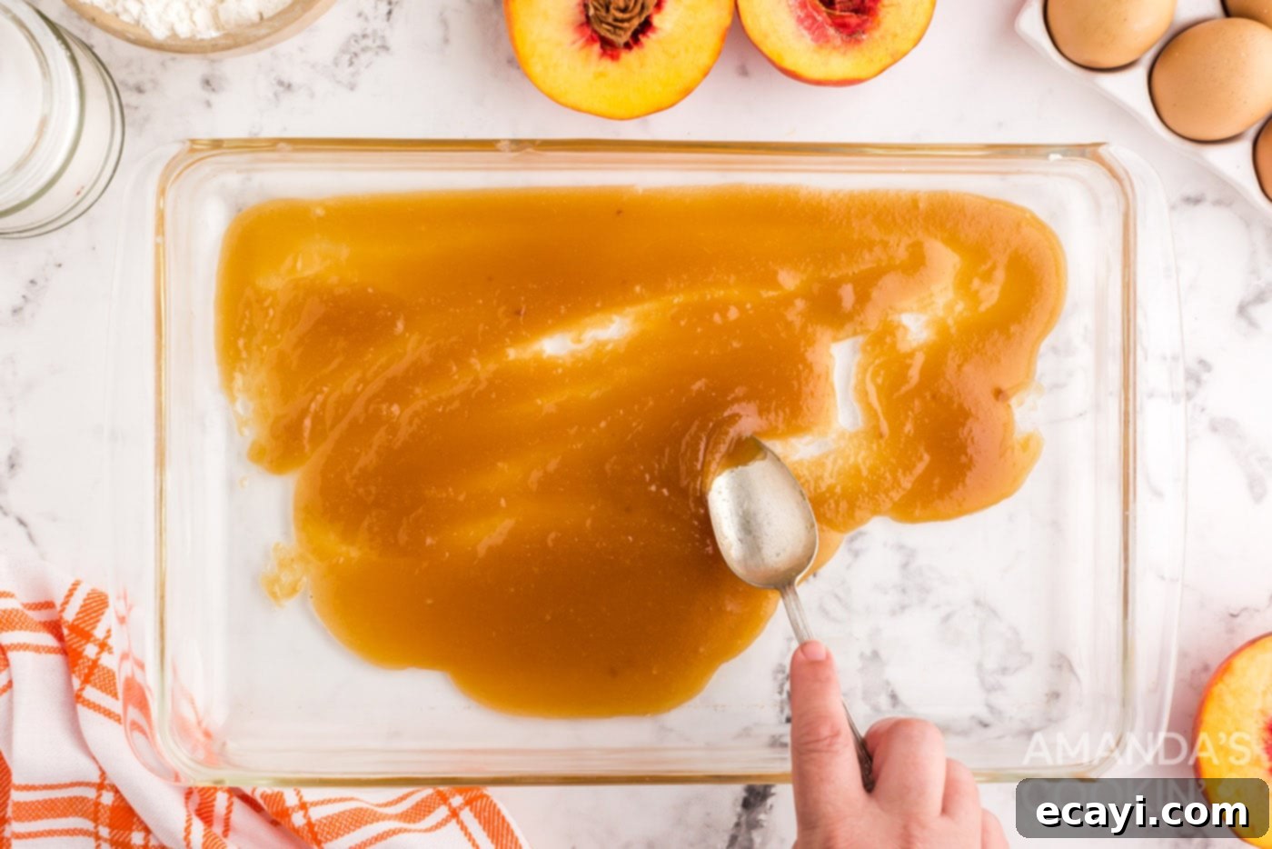 Golden Peach Crown Cake 5 Melted butter and brown sugar mixture spread evenly in a glass baking dish, forming the caramelized base for the cake.