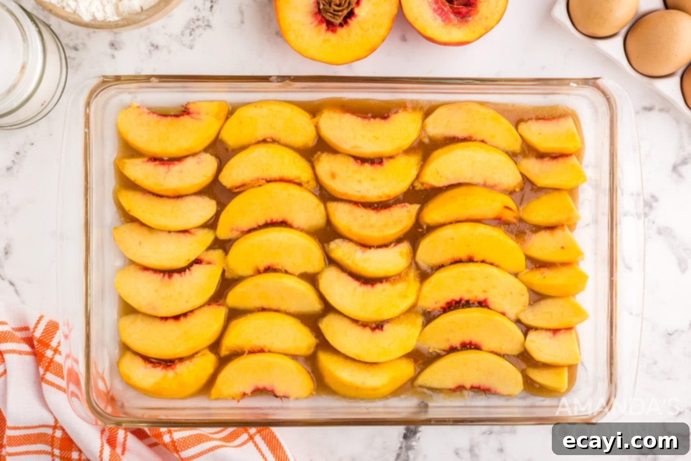 Golden Peach Crown Cake 6 Fresh peach slices carefully arranged in a pattern over the melted butter and brown sugar mixture in the baking dish.