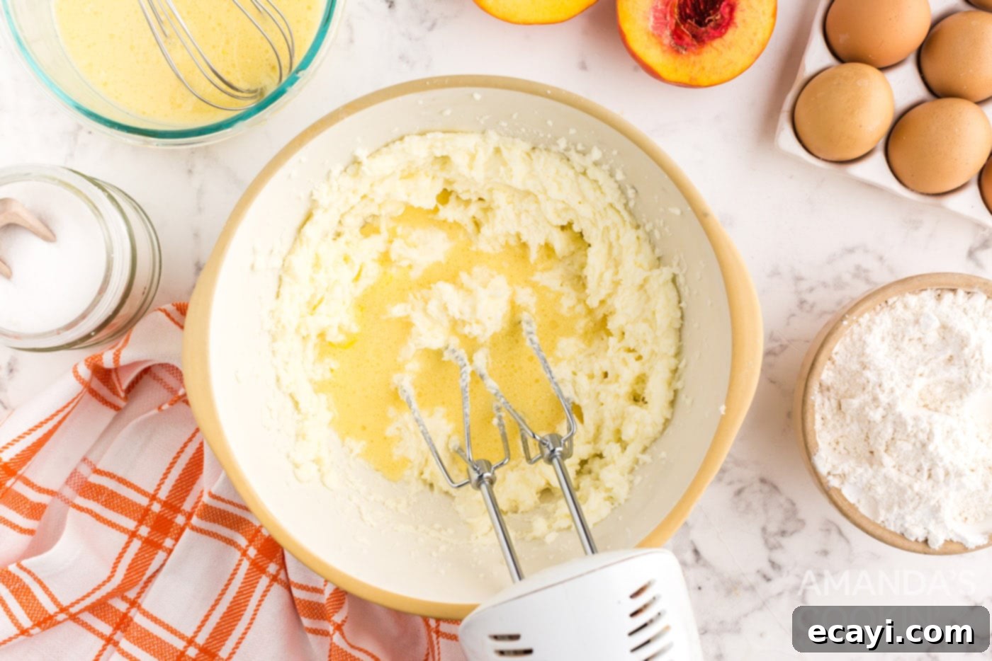 Golden Peach Crown Cake 8 Electric mixer beating cake batter in a bowl, showcasing the creamy consistency.