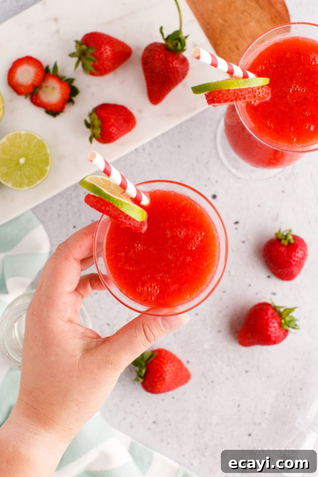 Frozen Strawberry Delight 6 hand reaching for a Strawberry Daiquiri in a hurricane glass