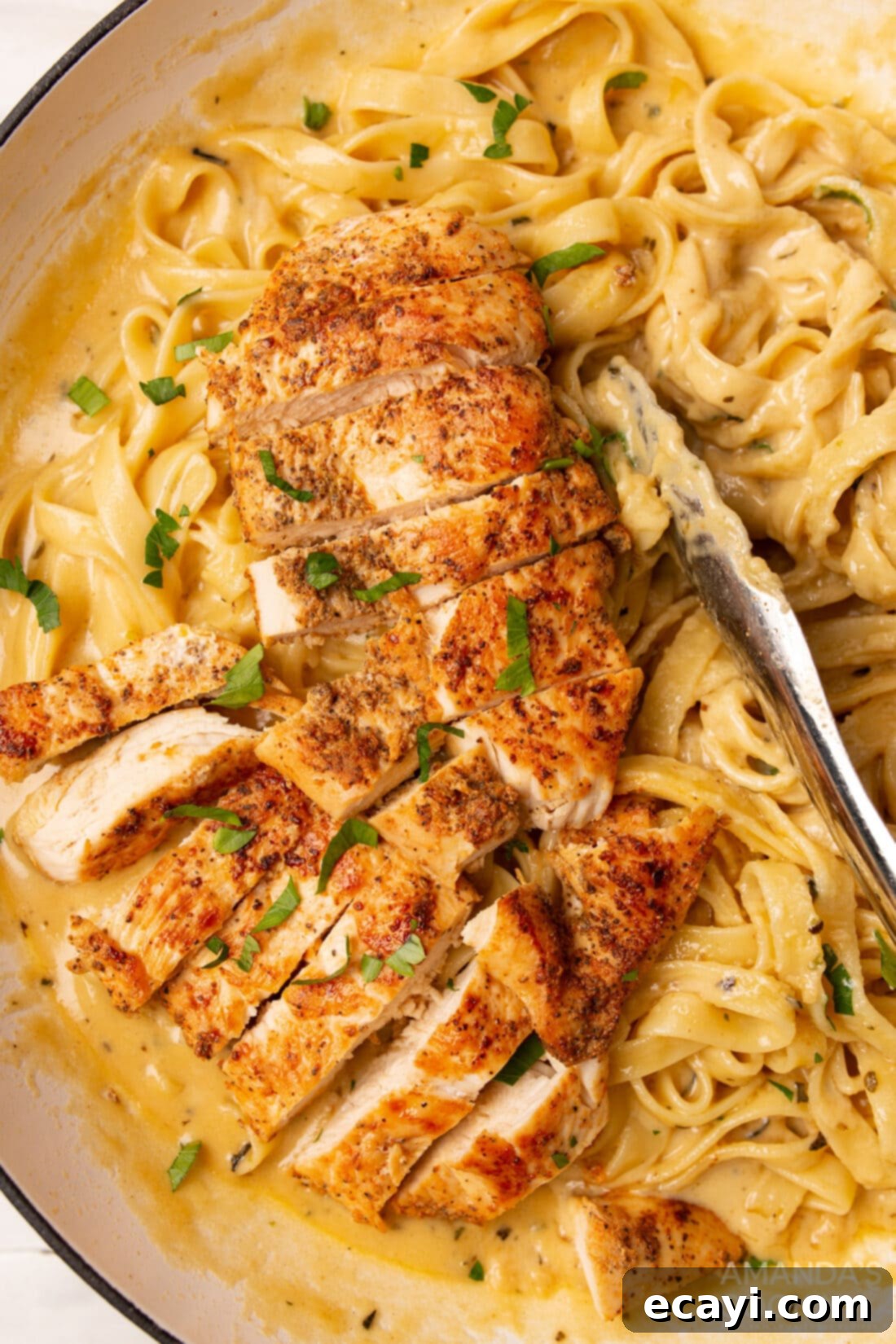 Creamy Chicken Alfredo 2 Chicken Alfredo with tongs, showcasing a serving of pasta and chicken