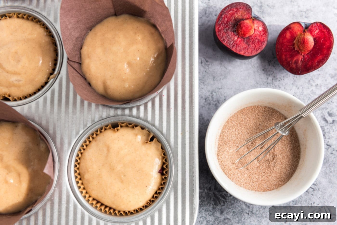 Sparkling Sugar Plum Muffins 15 A small bowl with cinnamon sugar mixture next to muffin batter in a pan, ready for sprinkling.