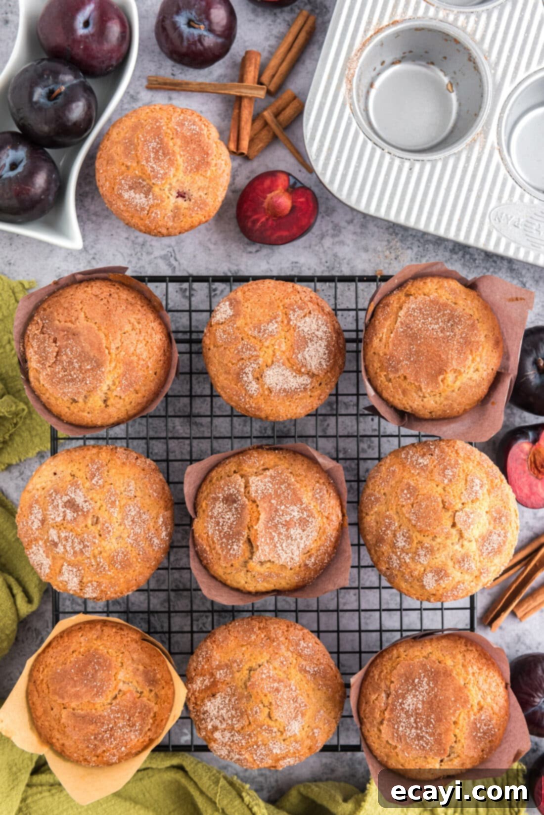 Sparkling Sugar Plum Muffins 18 Freshly baked Sugar Crusted Plum Muffins resting on a wire rack, allowing them to cool completely.