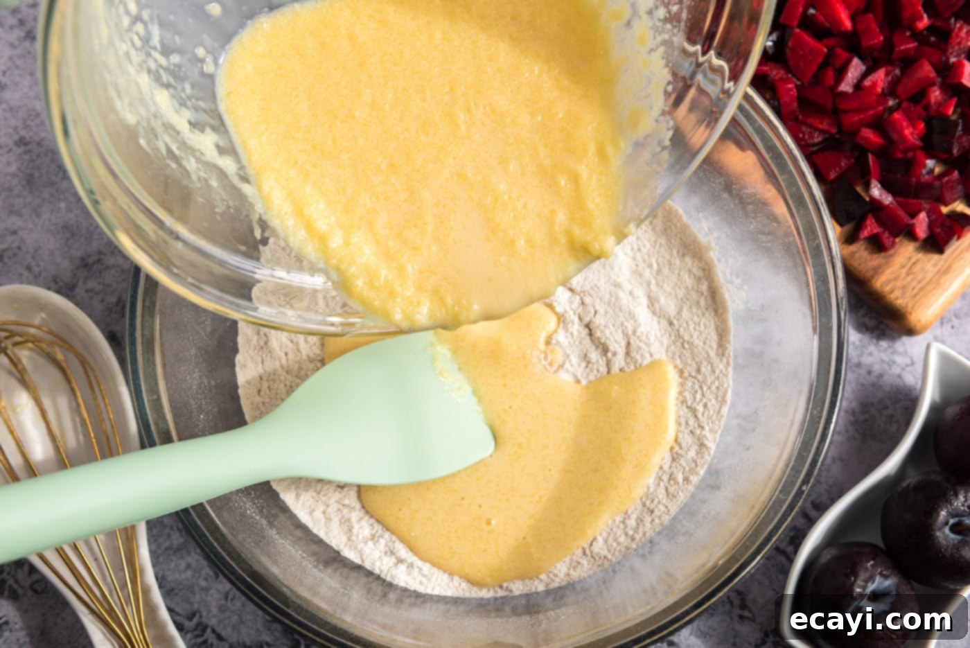 Sparkling Sugar Plum Muffins 9 The wet egg mixture being poured into the bowl of dry ingredients for the muffin batter.
