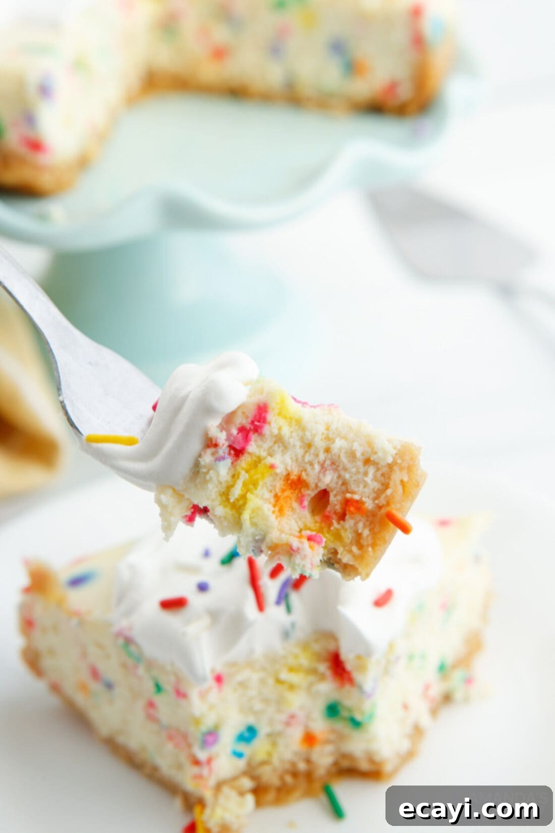 Effortless Instant Pot Funfetti Cheesecake 11 A fork taking a bite of Instant Pot Funfetti Cheesecake