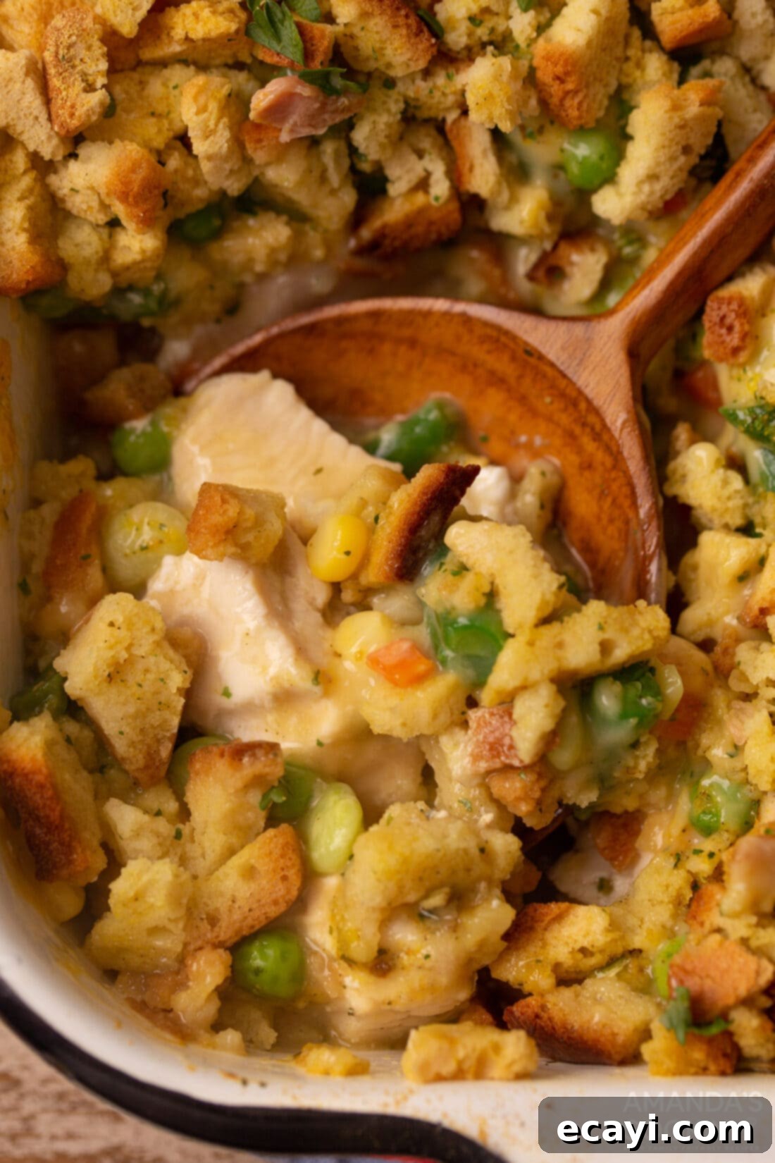 Savory Chicken and Stuffing Bake 2 wooden spoon in dish of Chicken Stuffing Casserole