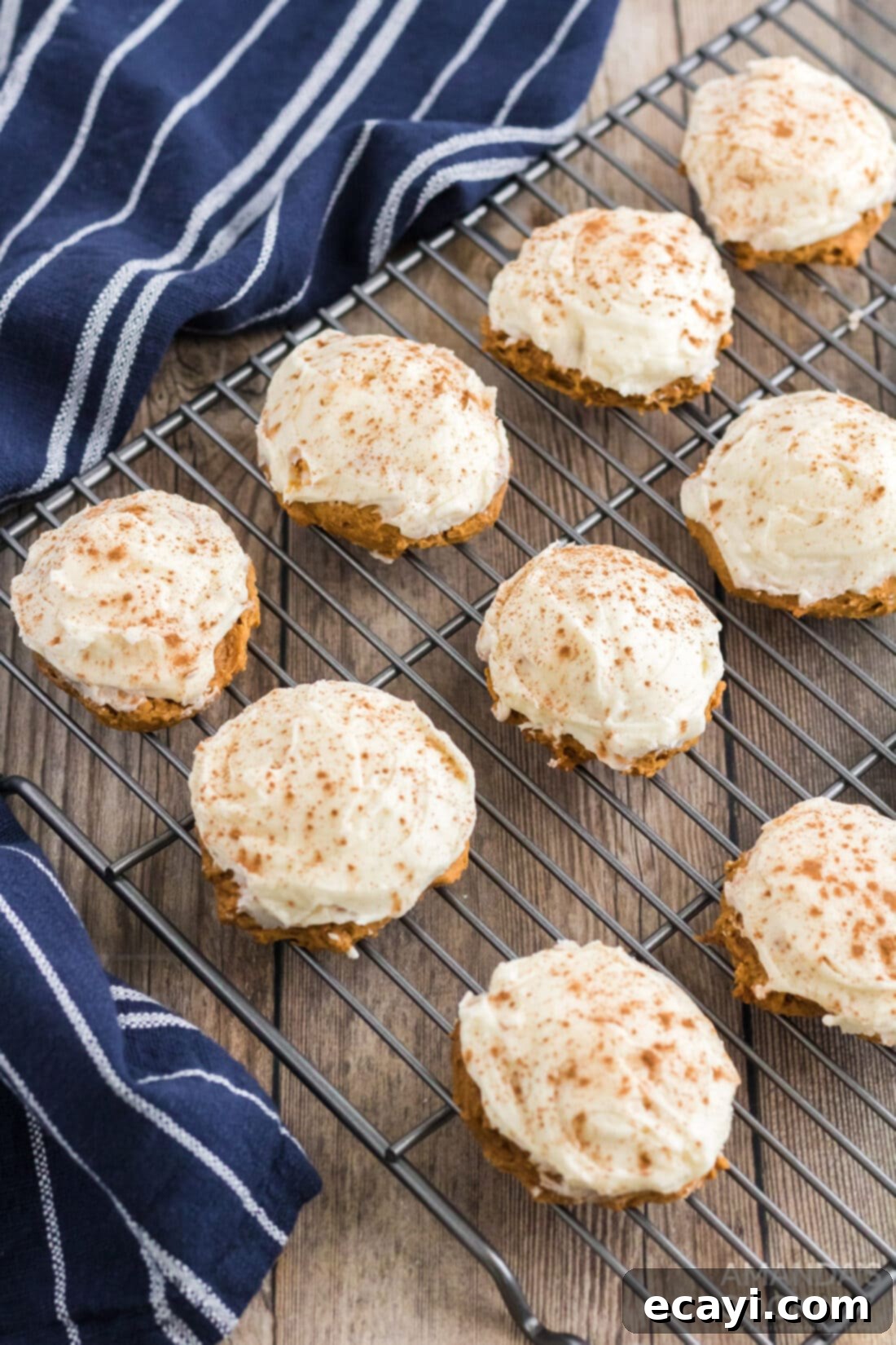 Easy Pumpkin Cake Mix Cookies 2 Pumpkin Cake Mix Cookies on a wire rack cooling after being frosted