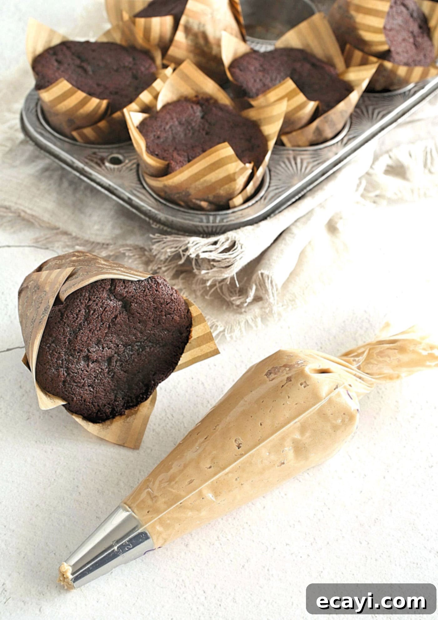Irresistible Chocolate Peanut Butter Cupcakes 6 Piping bag filled with peanut butter frosting, ready to decorate chocolate cupcakes