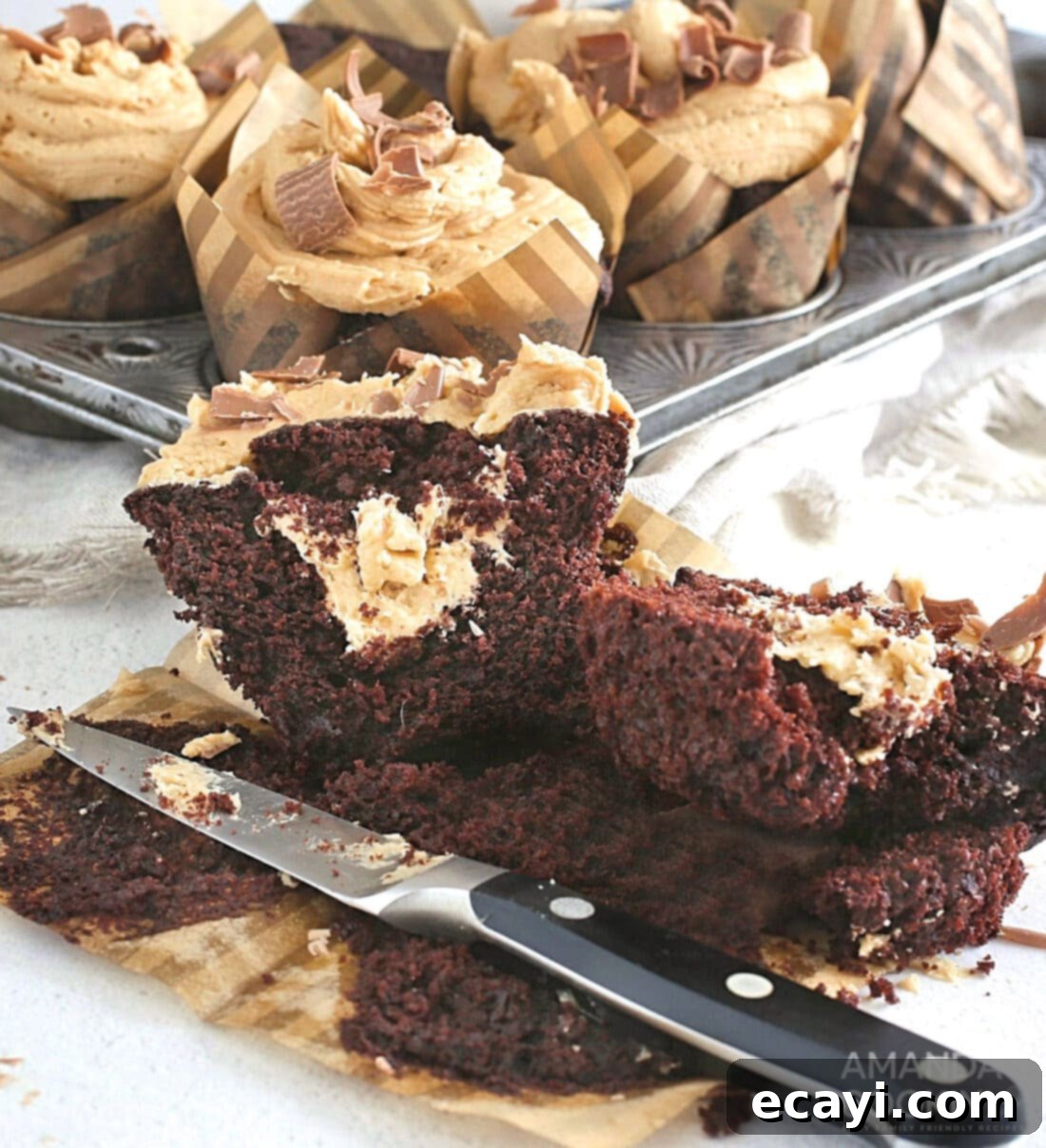 Irresistible Chocolate Peanut Butter Cupcakes 8 A chocolate peanut butter cupcake cut open to reveal a luscious peanut butter filling inside, showcasing its decadent layers.