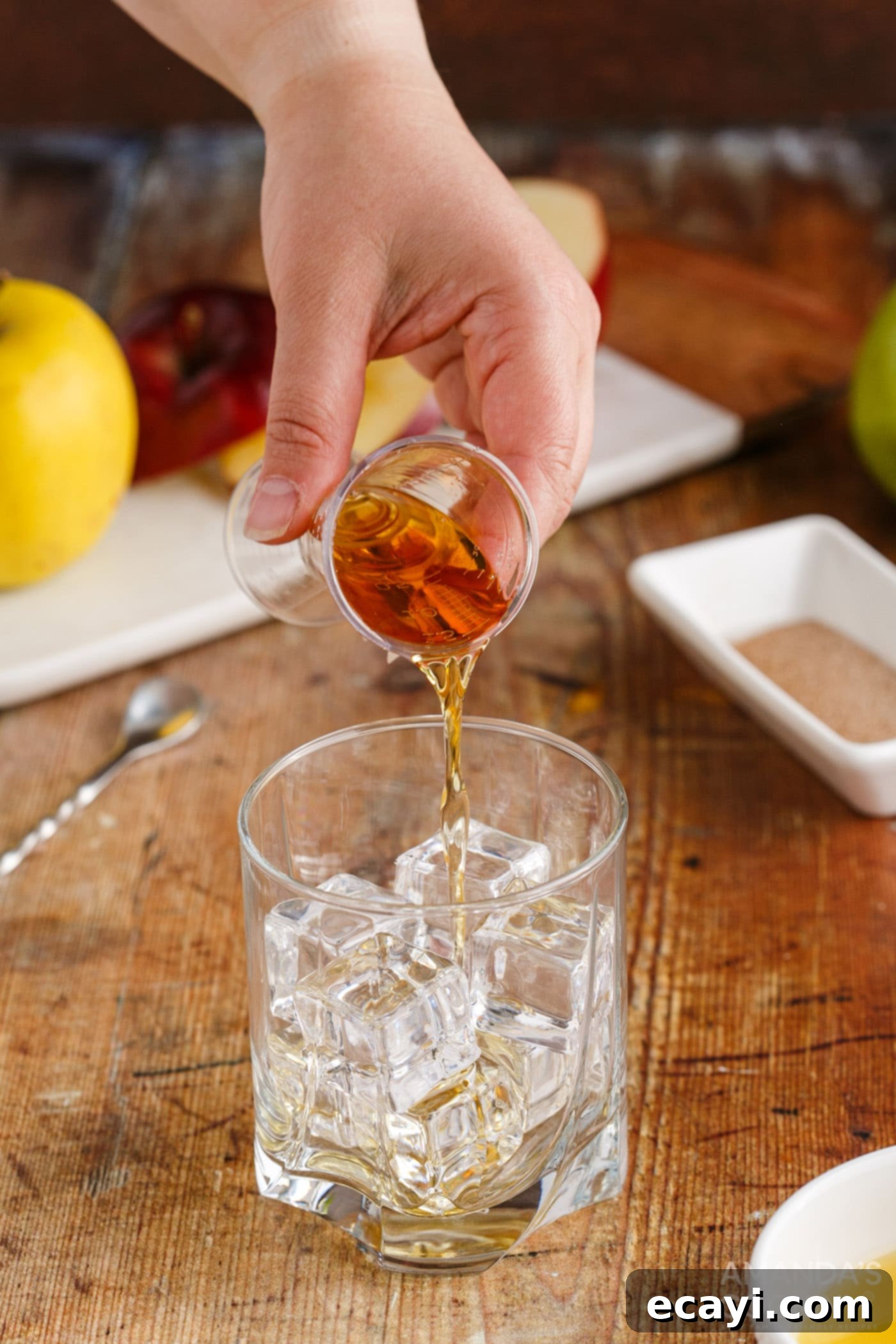 Harvest Spice Apple Elixir 5 pouring fireball whiskey into a shot glass for measurement