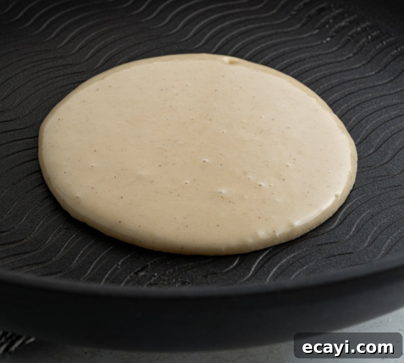 Fluffy Apple Pancakes 9 A pancake cooking on a hot griddle