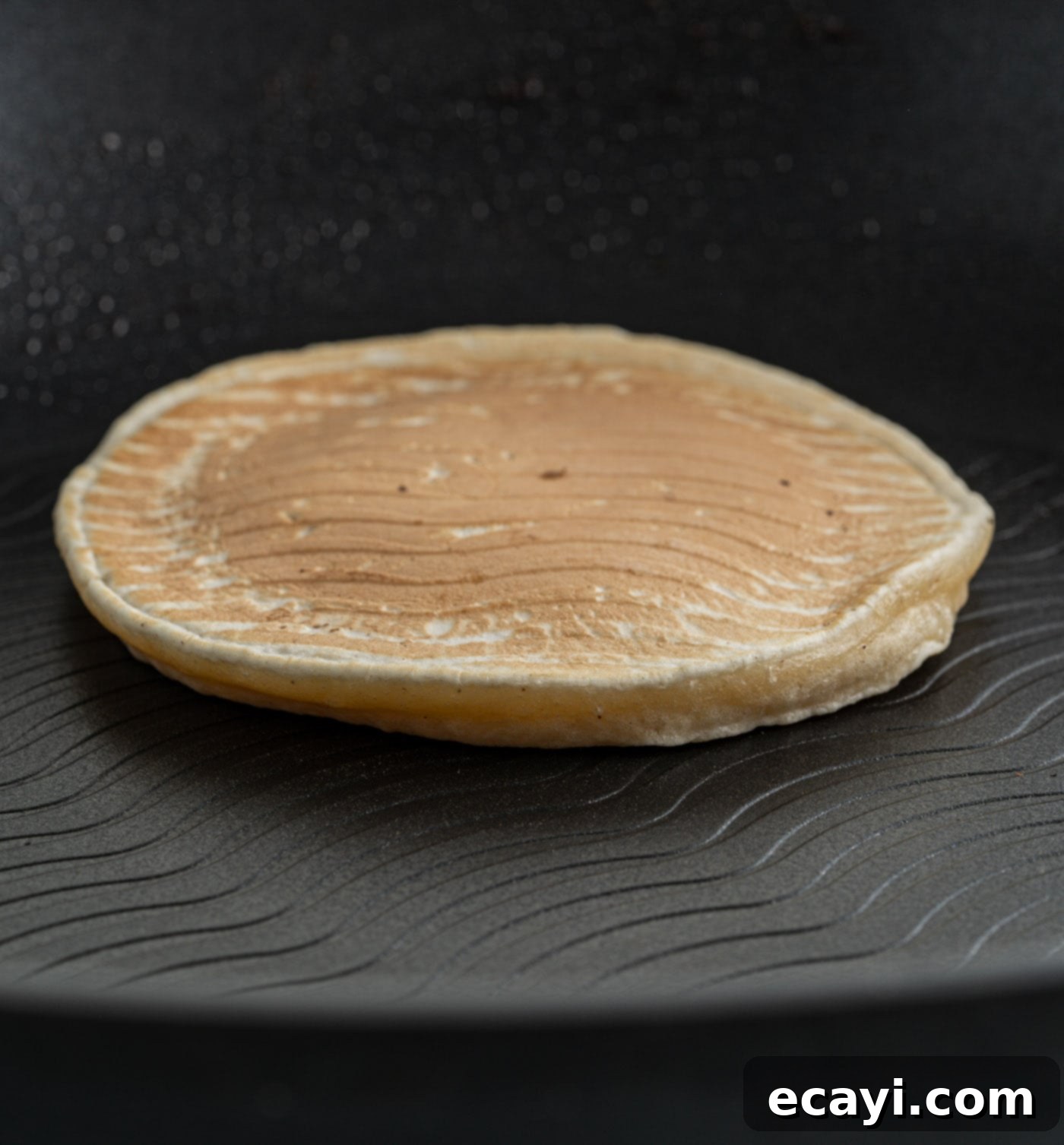 Fluffy Apple Pancakes 10 A stack of cooked apple pancakes on a plate, ready to be topped