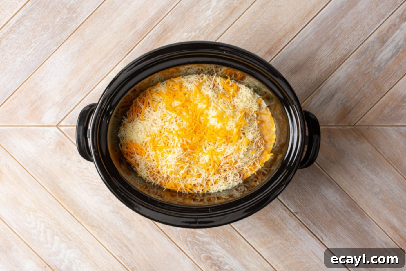 Slow Cooker Mexican Shredded Chicken 8 cheese on top of crockpot mexican chicken