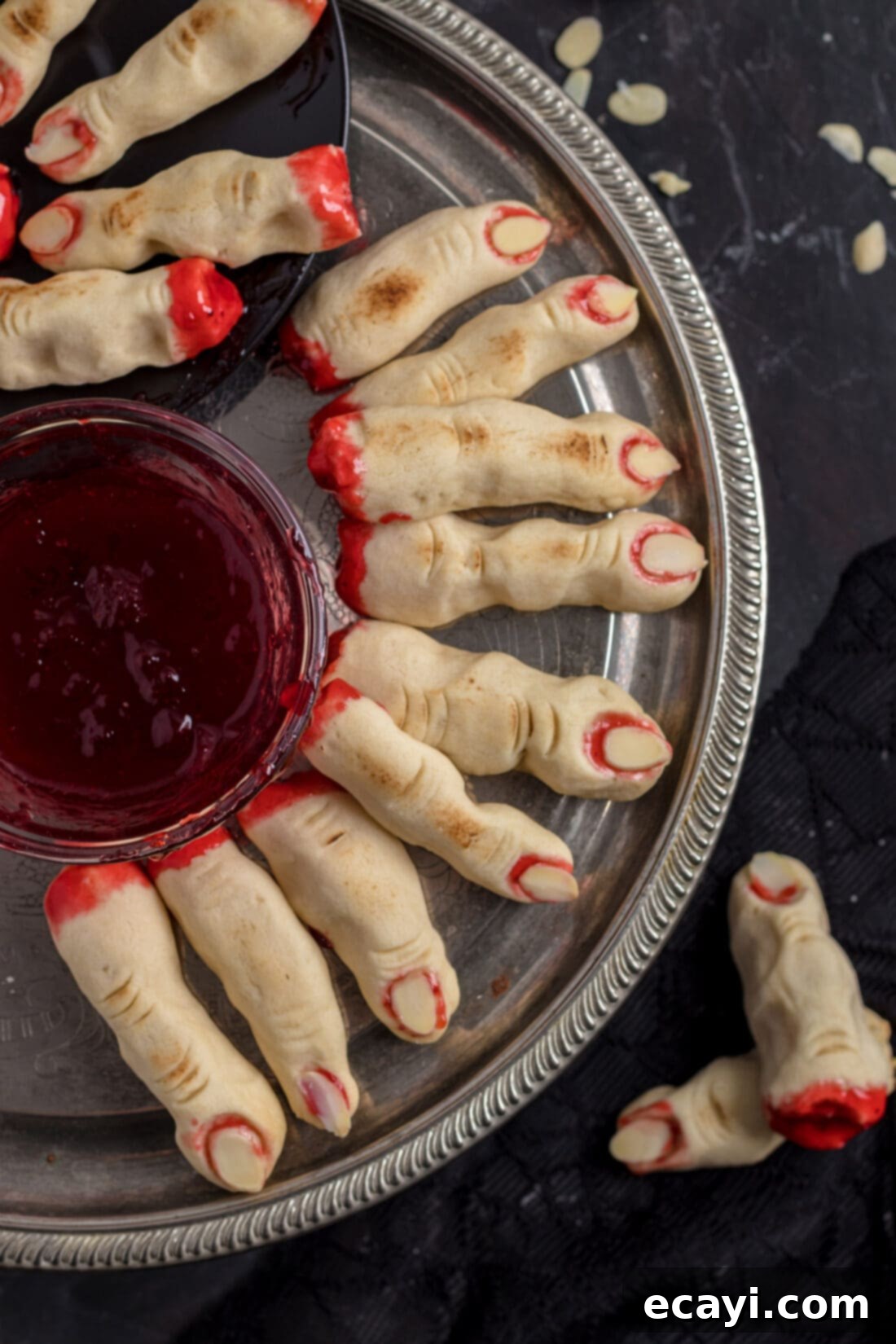 Wicked Fingers 3 A festive platter of Witch Finger Cookies with realistic almond fingernails and strawberry jam, arranged for a Halloween party