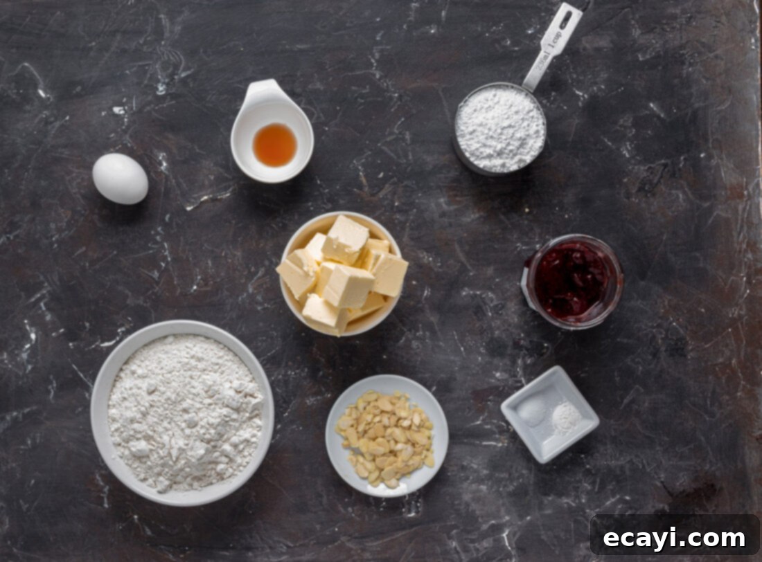 Wicked Fingers 4 A flat lay of ingredients for Witch Finger Cookies, including butter, flour, sugar, eggs, almonds, and strawberry jam