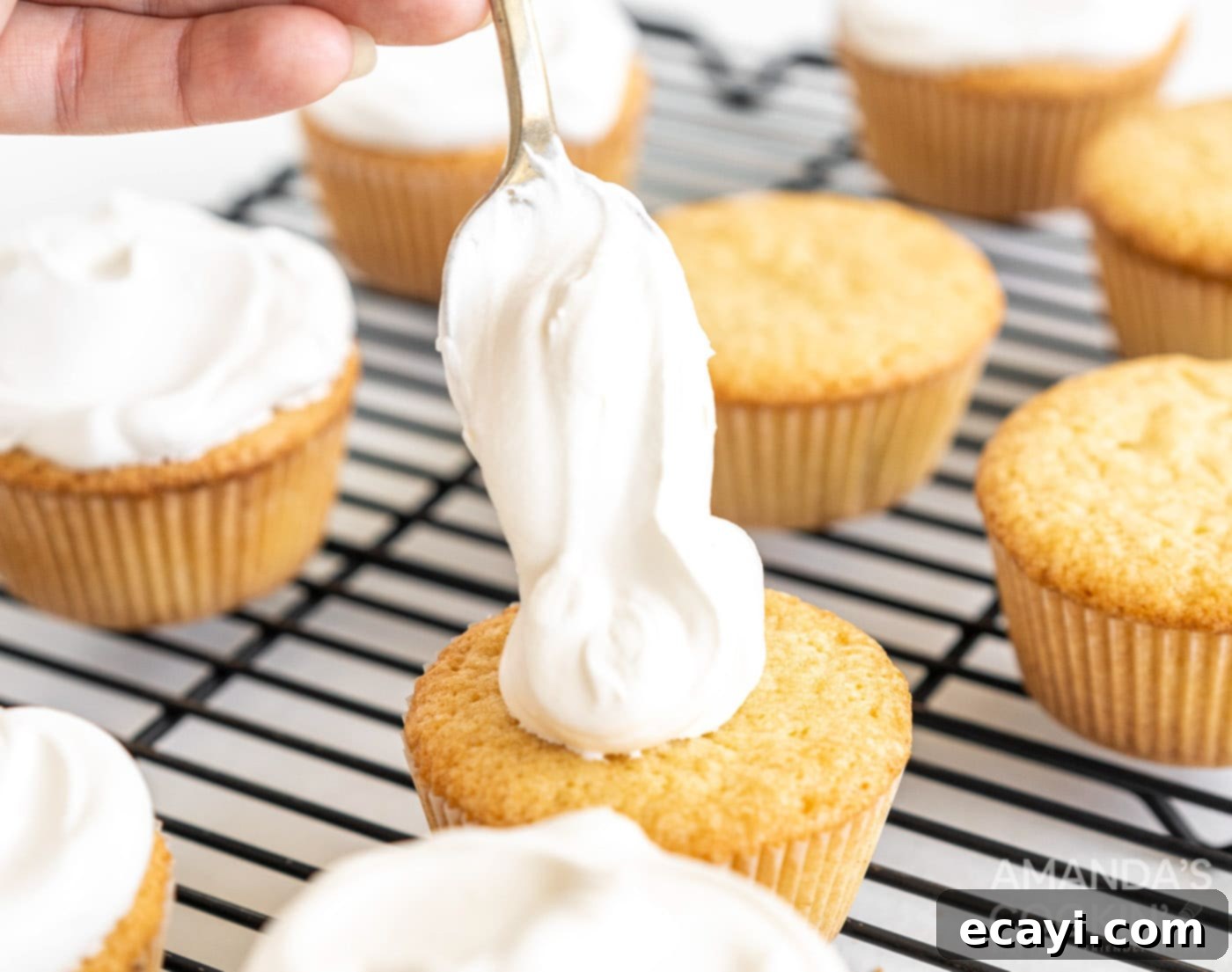 Golden Pound Cupcakes 10 spooning whipped cream on top of pound cake cupcakes